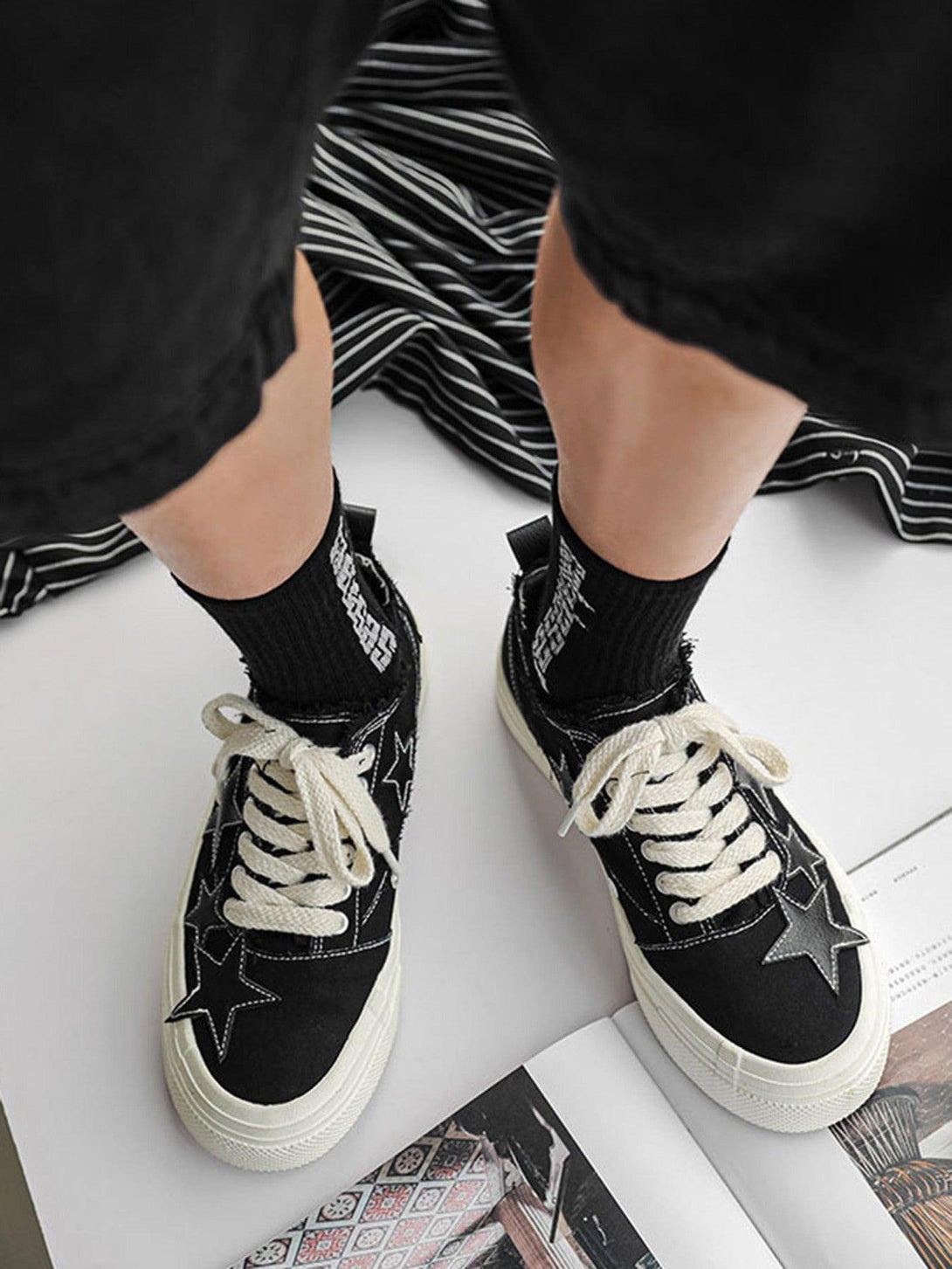TALISHKO shoes with retro star accents and textured white laces, worn casually with black shorts.