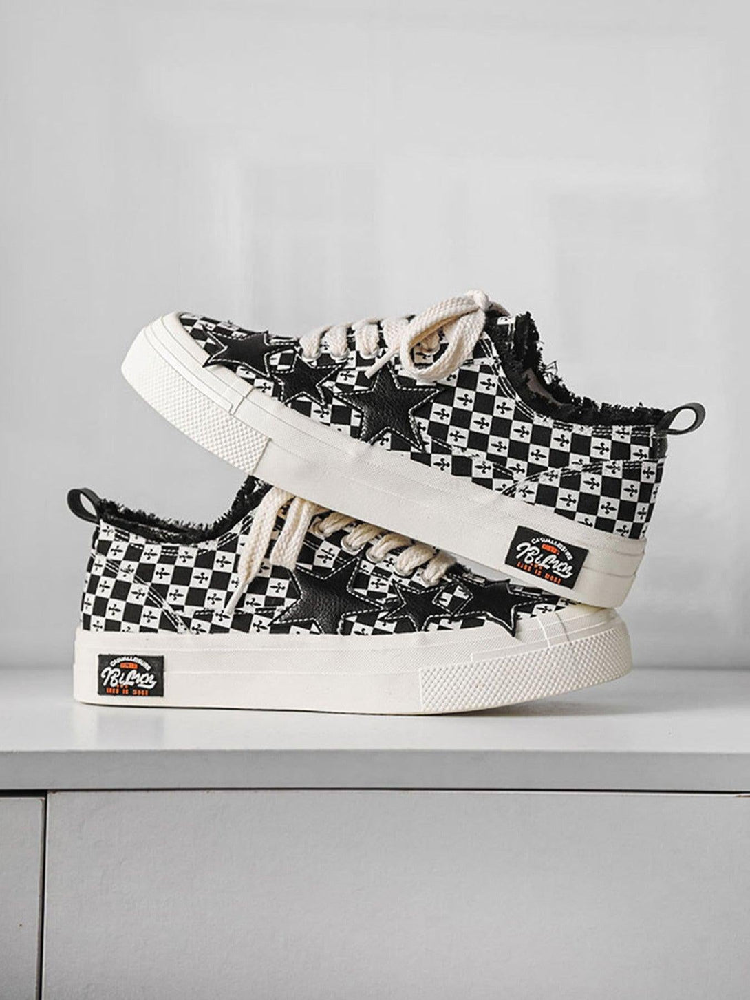 Retro-inspired canvas shoes by TALISHKO with star accents and a bold black and white check pattern.
