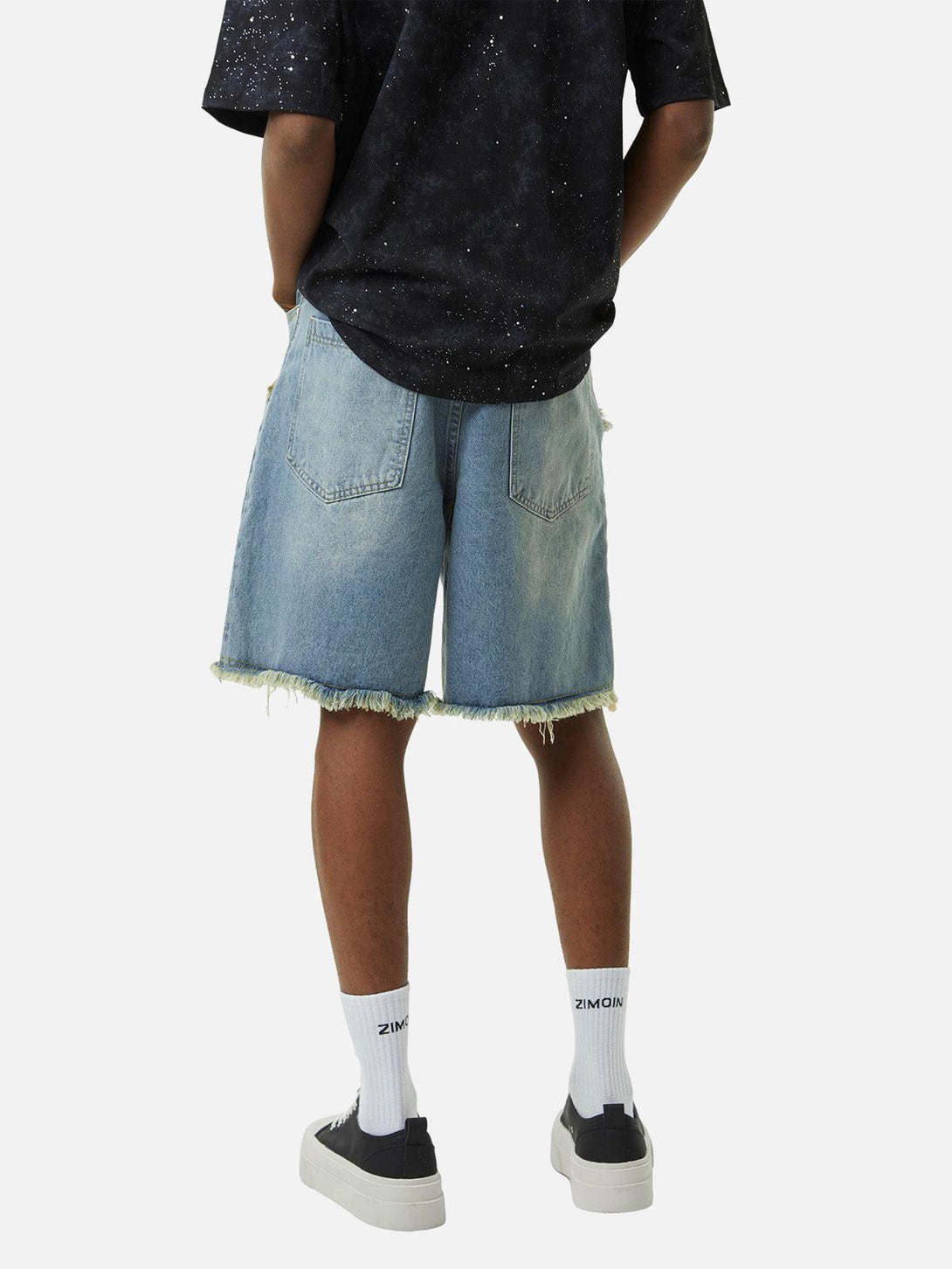 Model wearing TALISHKO denim shorts with frayed hems and retro stitching, perfect for casual outings.