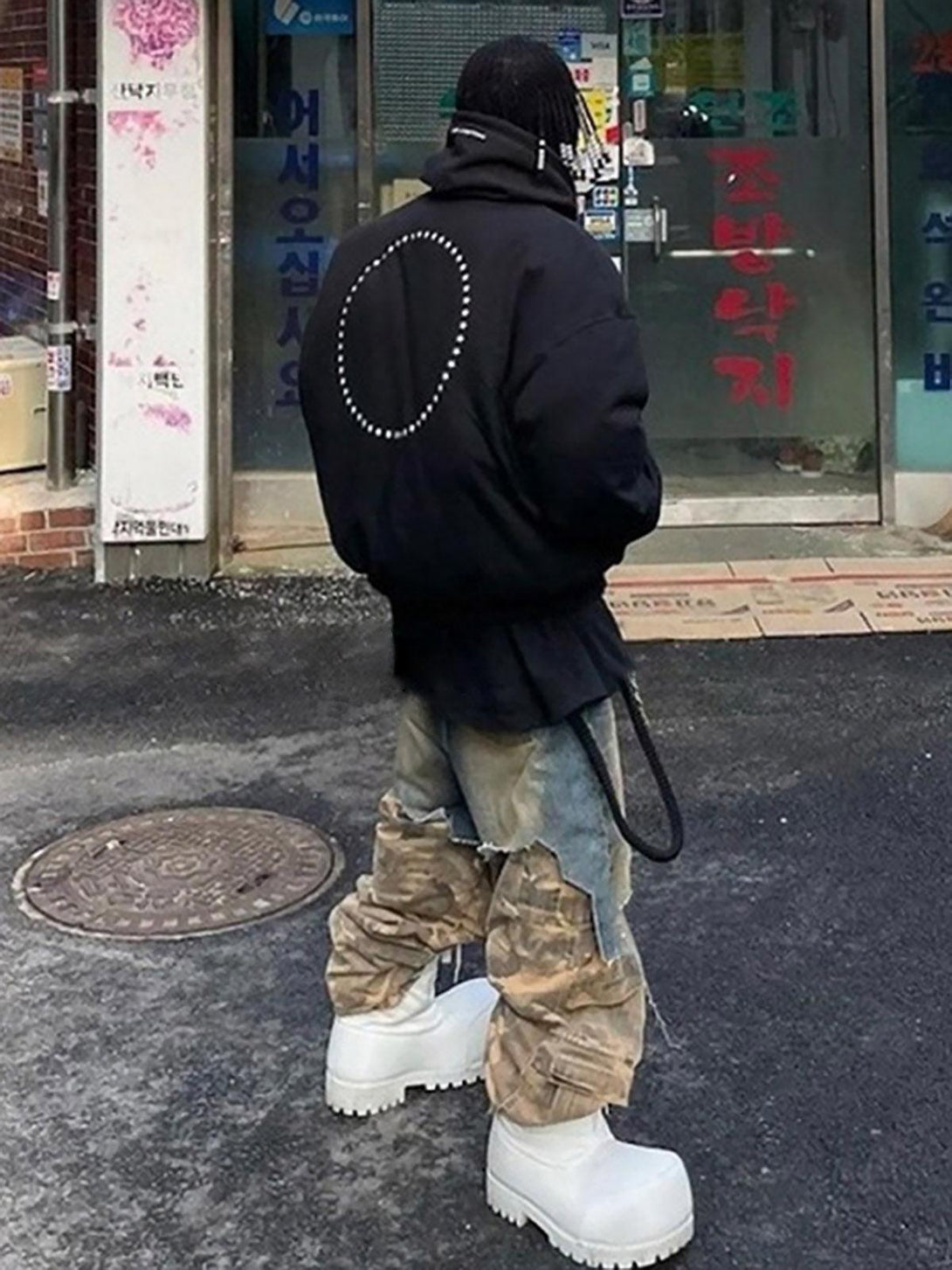 Model in TALISHKO's retro camouflage jeans, styled with edgy white platform boots.