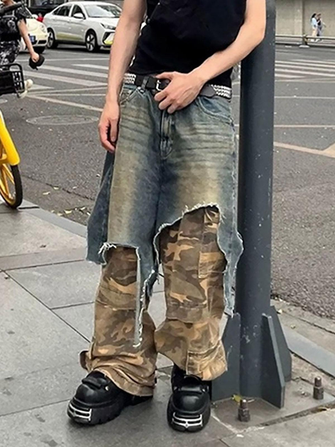 Model in TALISHKO's retro camouflage jeans, featuring a distressed denim overlay design.