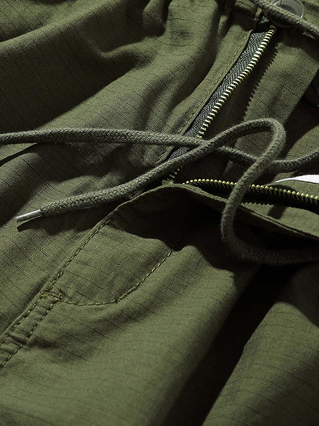 Intricate look at green retro casual pants by TALISHKO, highlighting drawstring and zipper details.