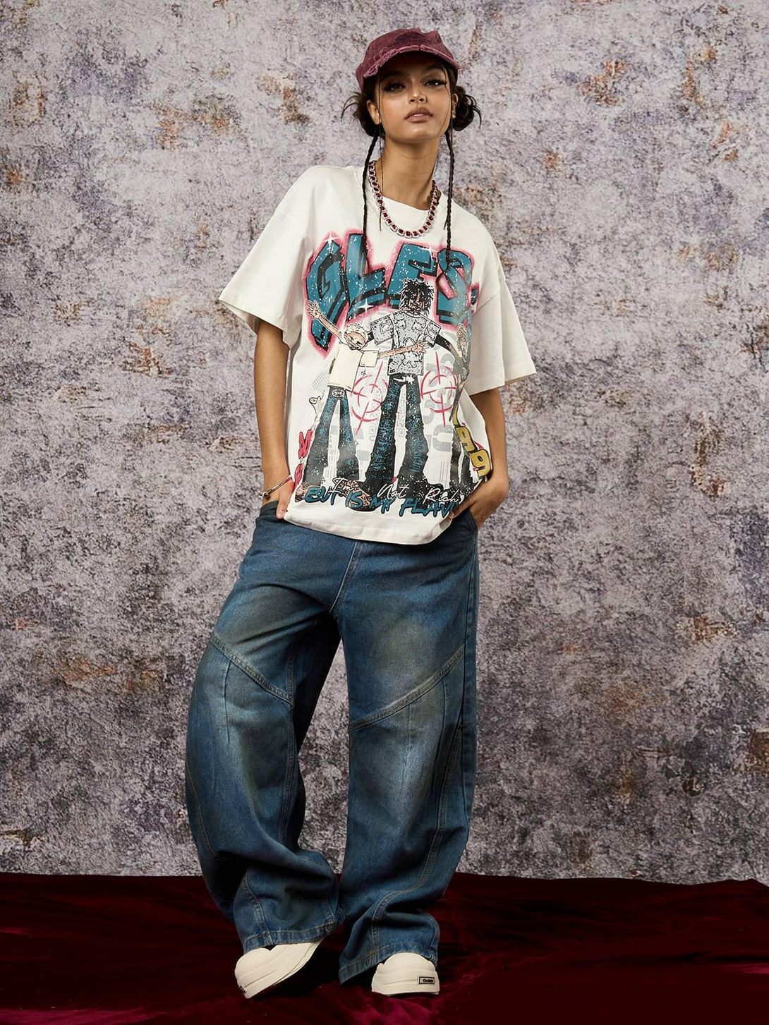 Model in TALISHKO's Retro Street GLESA graphic T-shirt, paired with wide-leg jeans and cap.