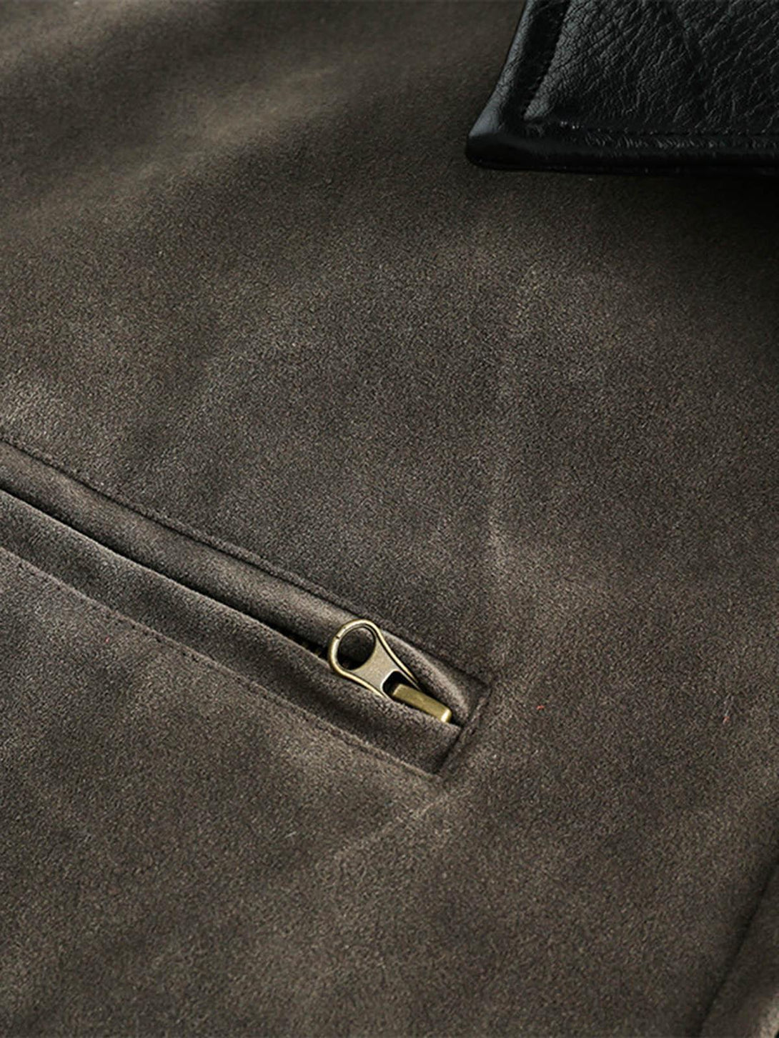 Intricate look at the TALISHKO retro suede motorcycle jacket's zipper detail and fabric texture.