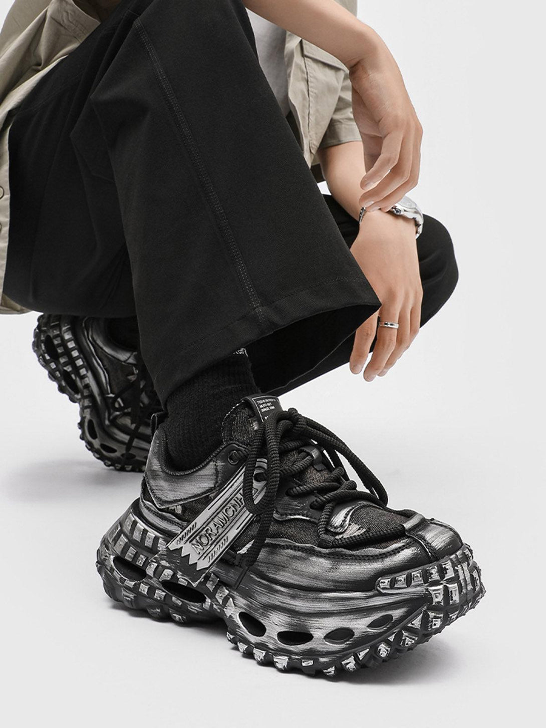 TALISHKO retro chunky sneakers with a bold tire sole, adding flair to casual black pants.