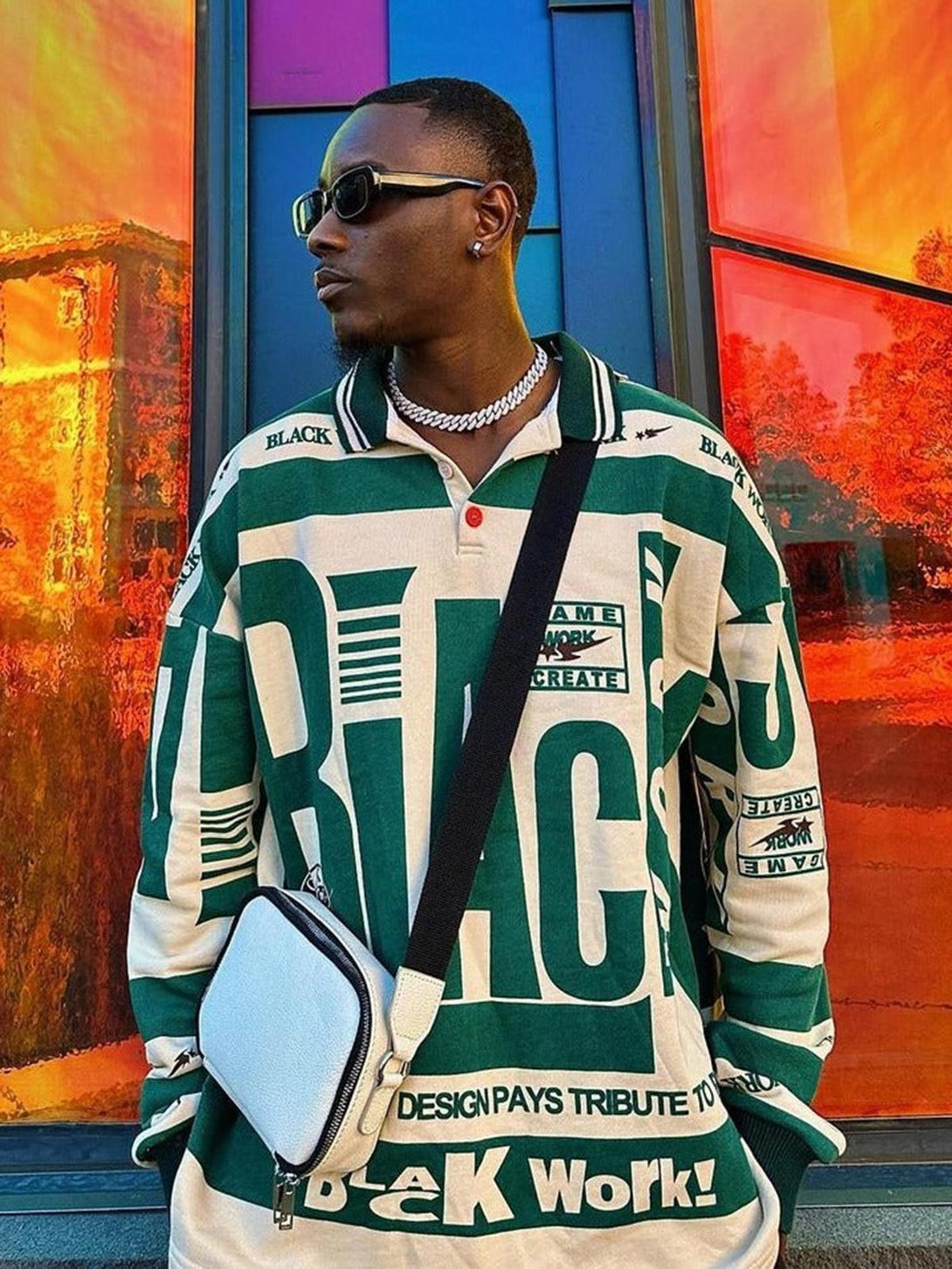 Model in a retro typography polo tee by TALISHKO, paired with stylish sunglasses and a crossbody bag.