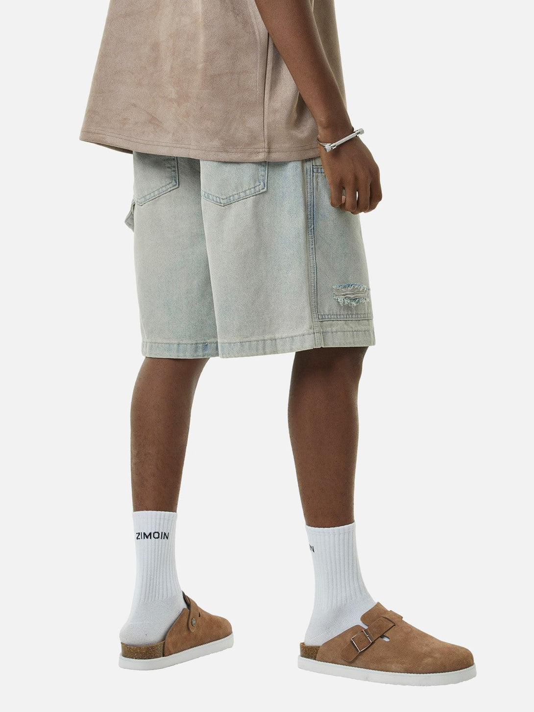 Model styled in TALISHKO retro washed hip-hop shorts with casual brown sandals and socks.