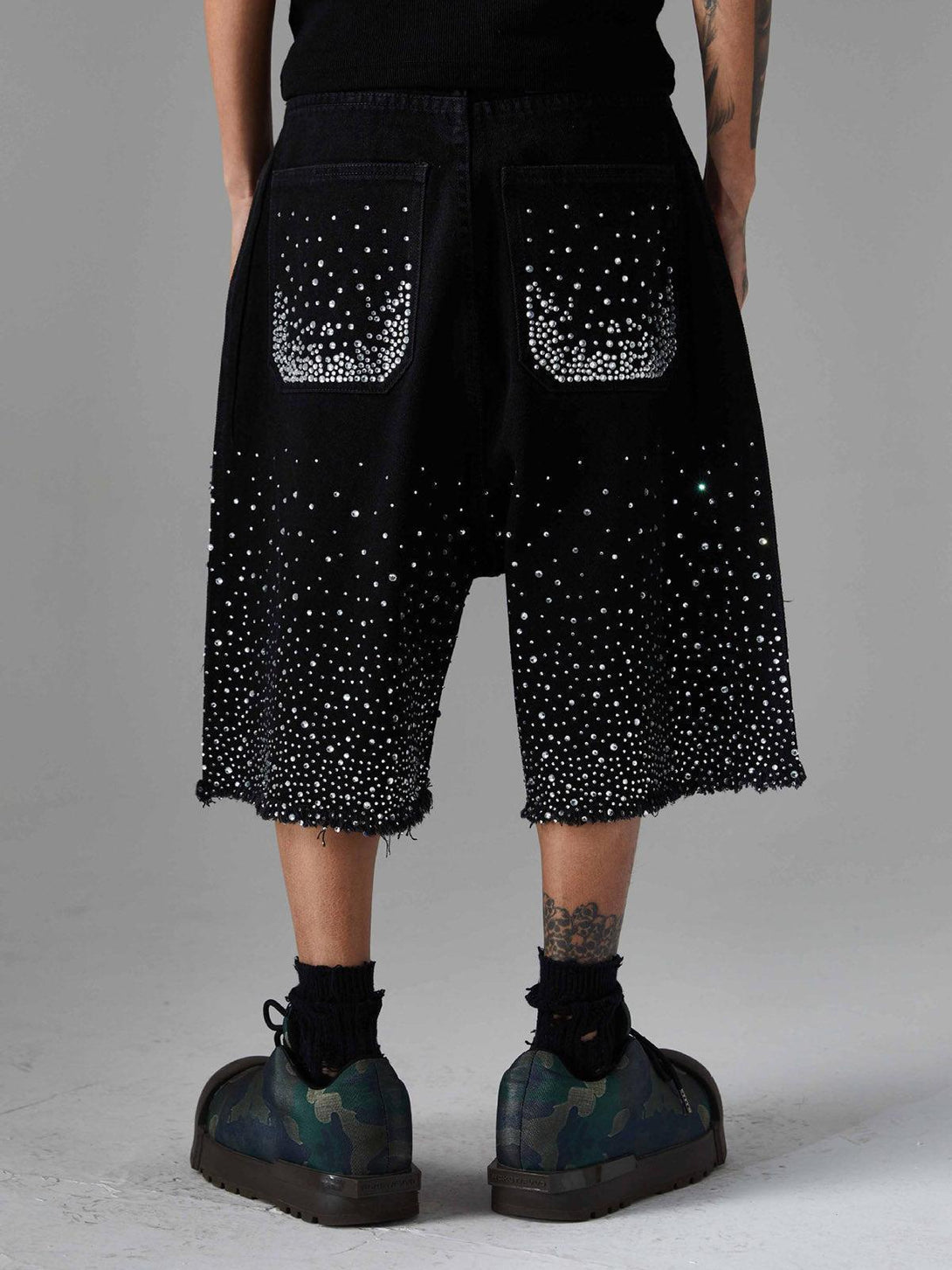 Back view of TALISHKO rhinestone denim shorts with raw edges, highlighting retro style.