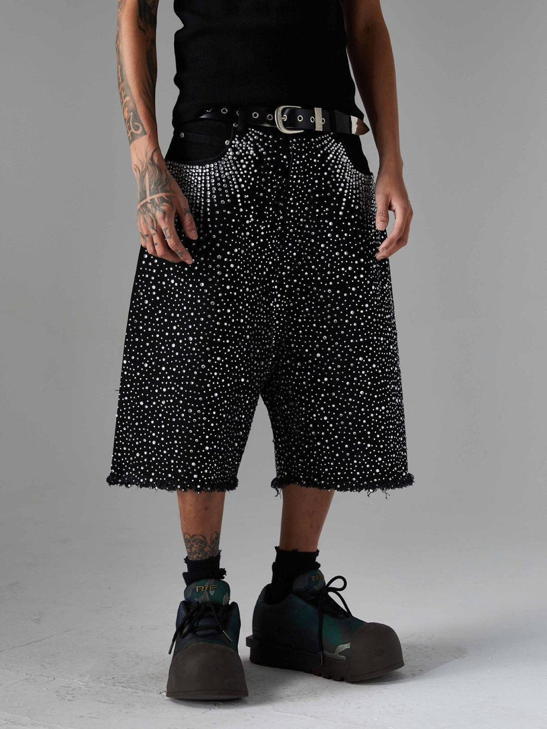 Model wearing TALISHKO retro denim shorts adorned with rhinestones and raw edges.