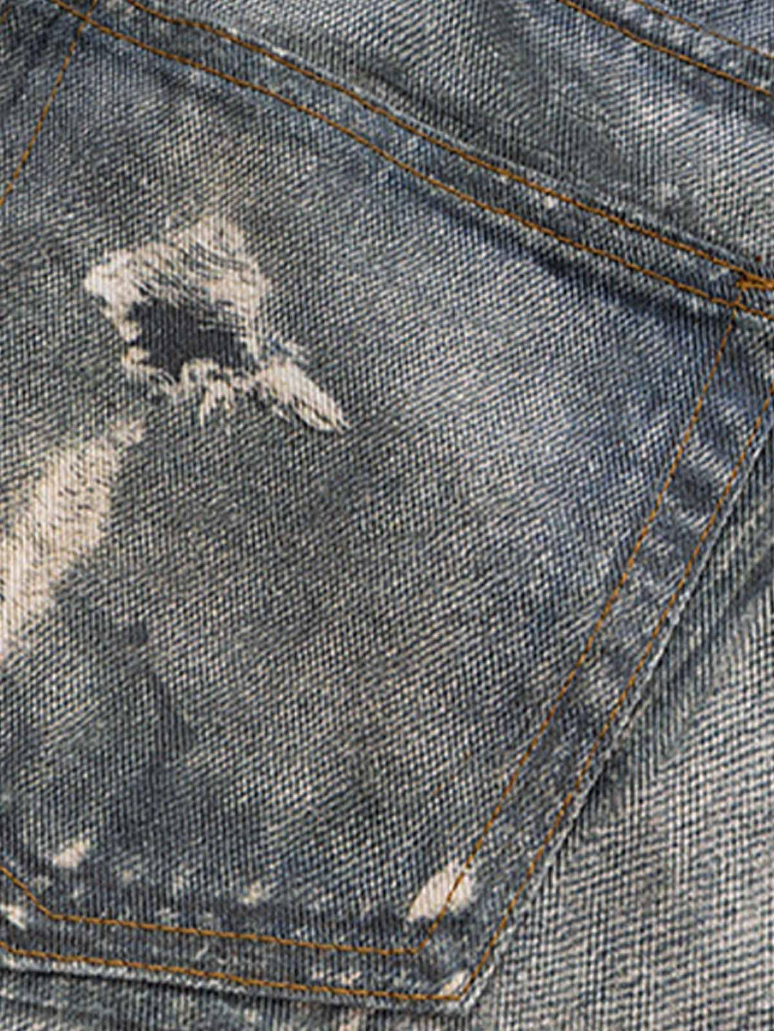 A close-up of the distressed details on TALISHKO's retro washed flare jeans, showcasing texture.