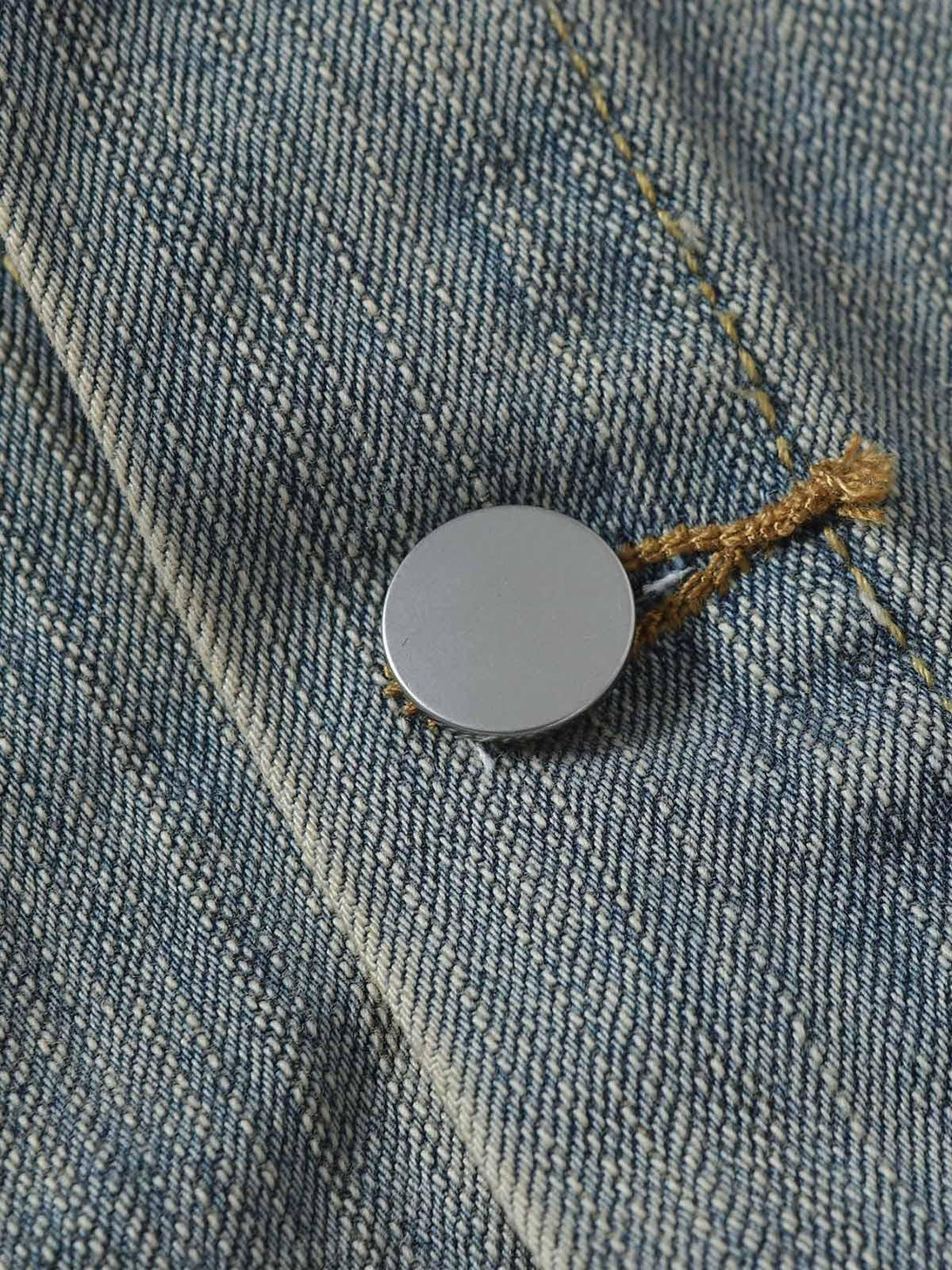 Intricate detail of TALISHKO's retro washed denim jacket, highlighting texture and stitching.