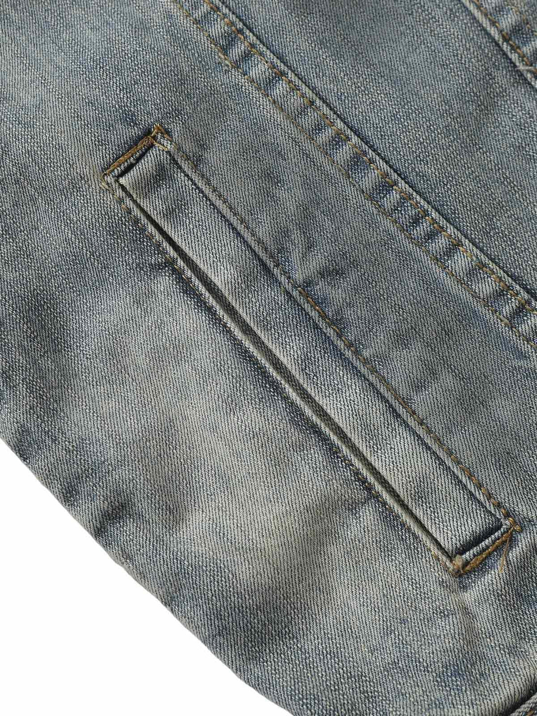 Textured view of TALISHKO's denim jacket pocket, showcasing retro washed detail.