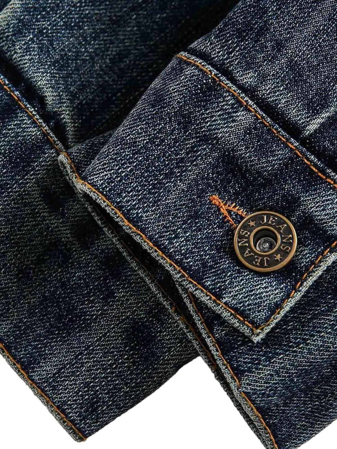 A tight crop highlighting the button and stitching detail on TALISHKO's denim jacket.