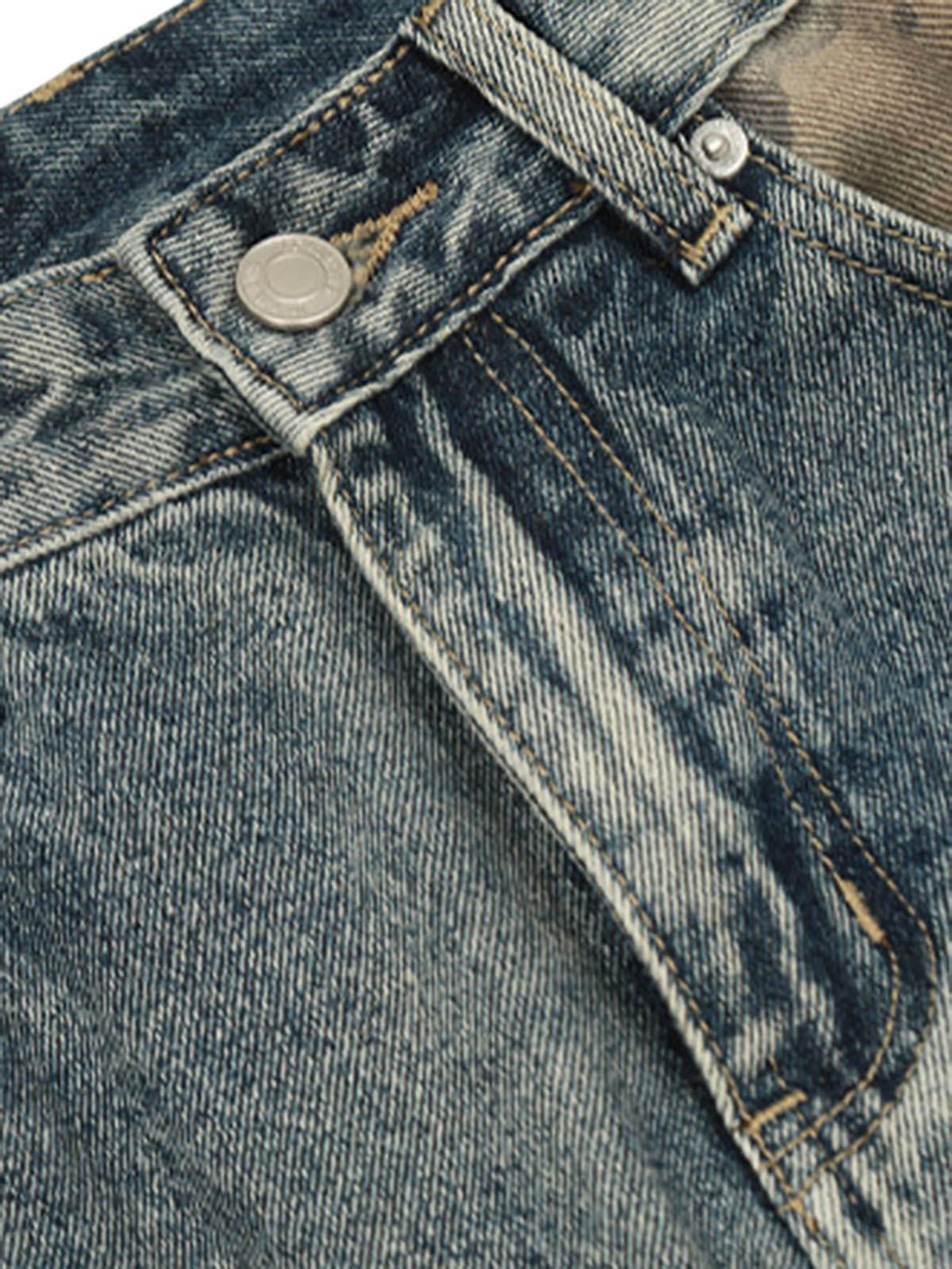 Close-up of TALISHKO's baggy jeans showcasing distressed denim and camouflage patchwork.