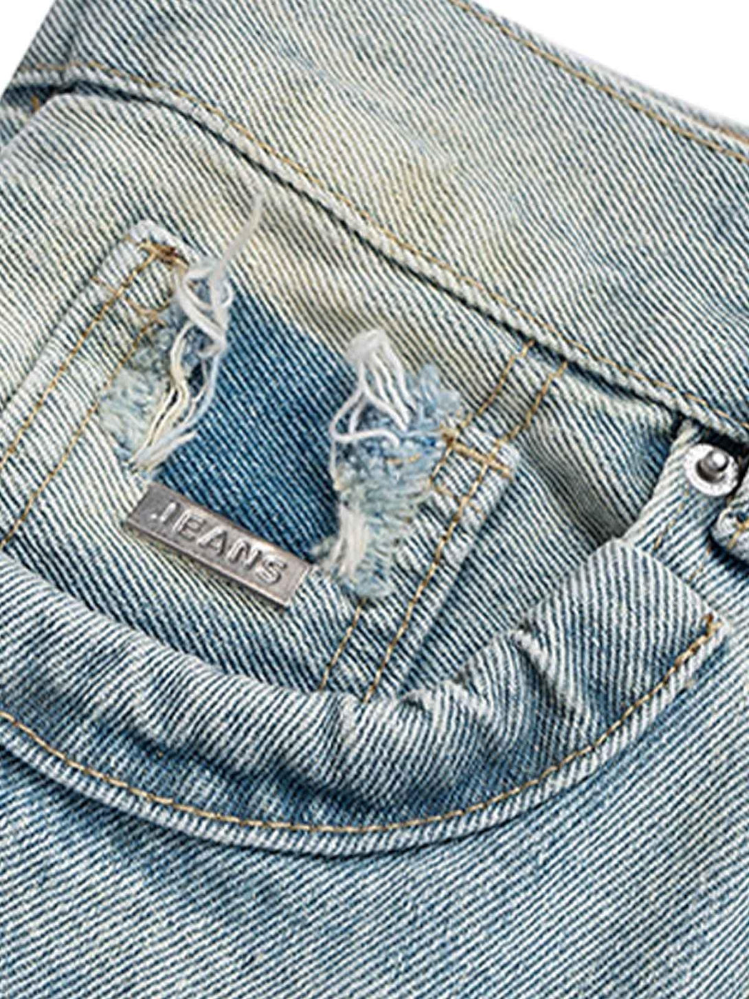 Intricate look at TALISHKO's ripped detail on baggy flare jeans, showcasing rugged texture.