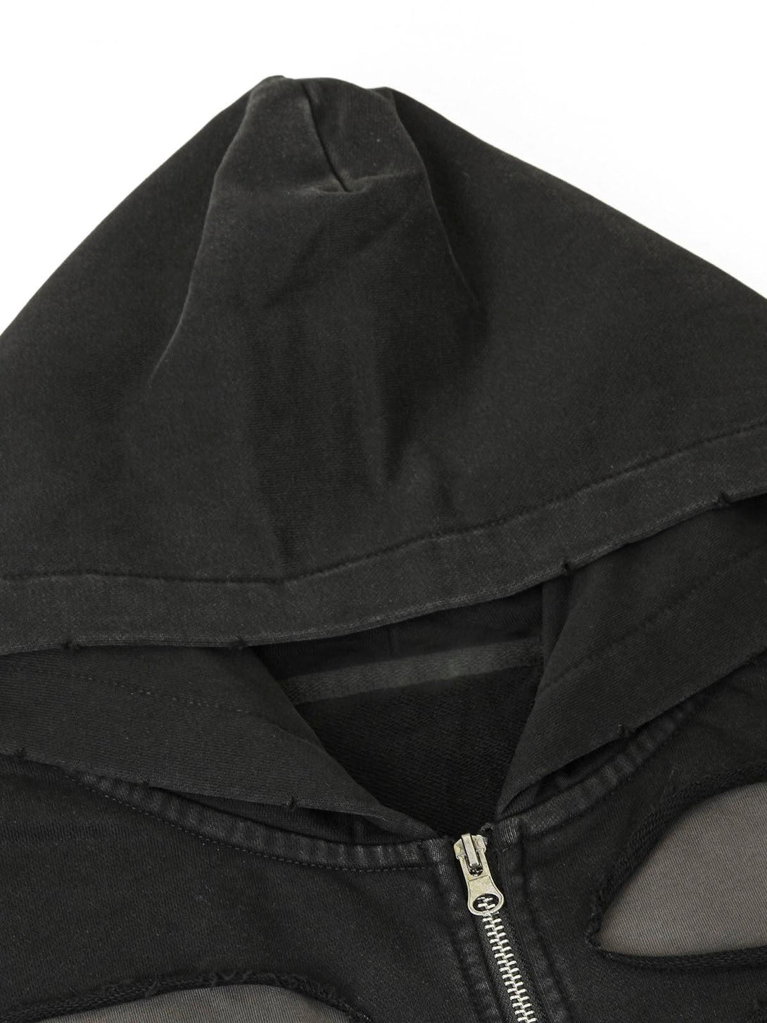 Detailed view of a black zip-up jacket hood and zipper by TALISHKO, highlighting design elements.