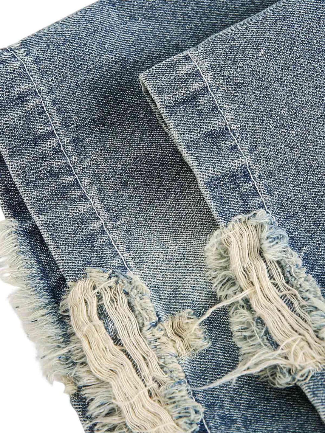 Detailed view of TALISHKO's denim shirt hem, highlighting distressed frayed edges.