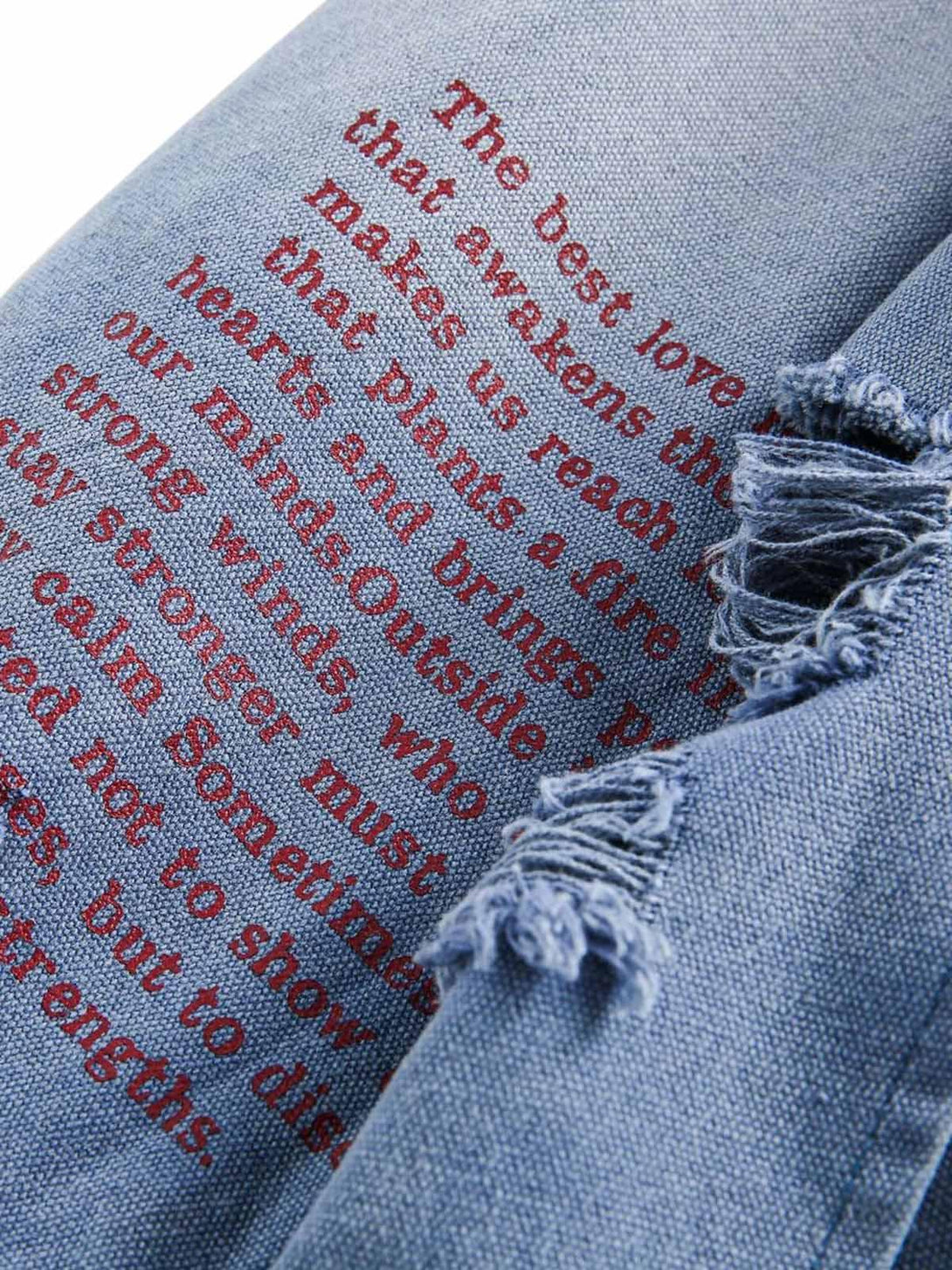 Detailed fabric and red graffiti text on a TALISHKO denim jacket, highlighting unique style.