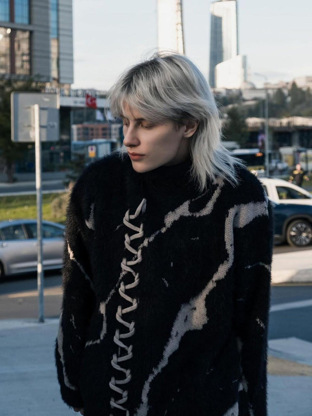 TALISHKO's stylish ripped knit turtleneck sweater, featuring a striking lace-up detail.