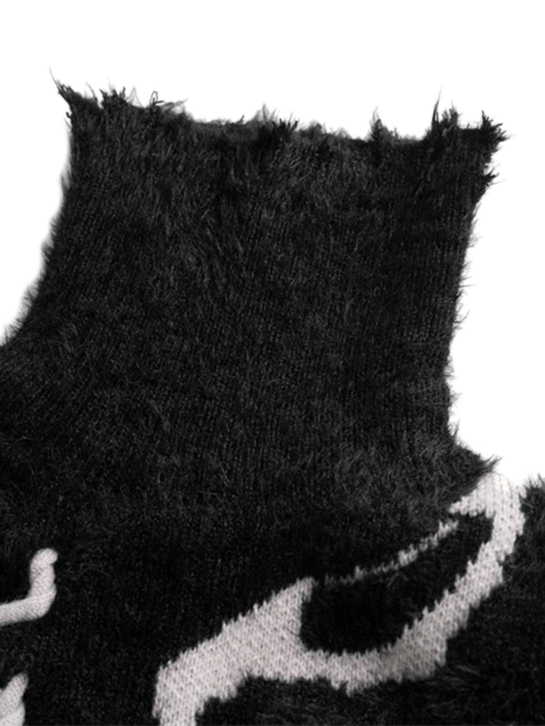 A detailed view of TALISHKO's black ripped knit turtleneck sweater fabric and texture.
