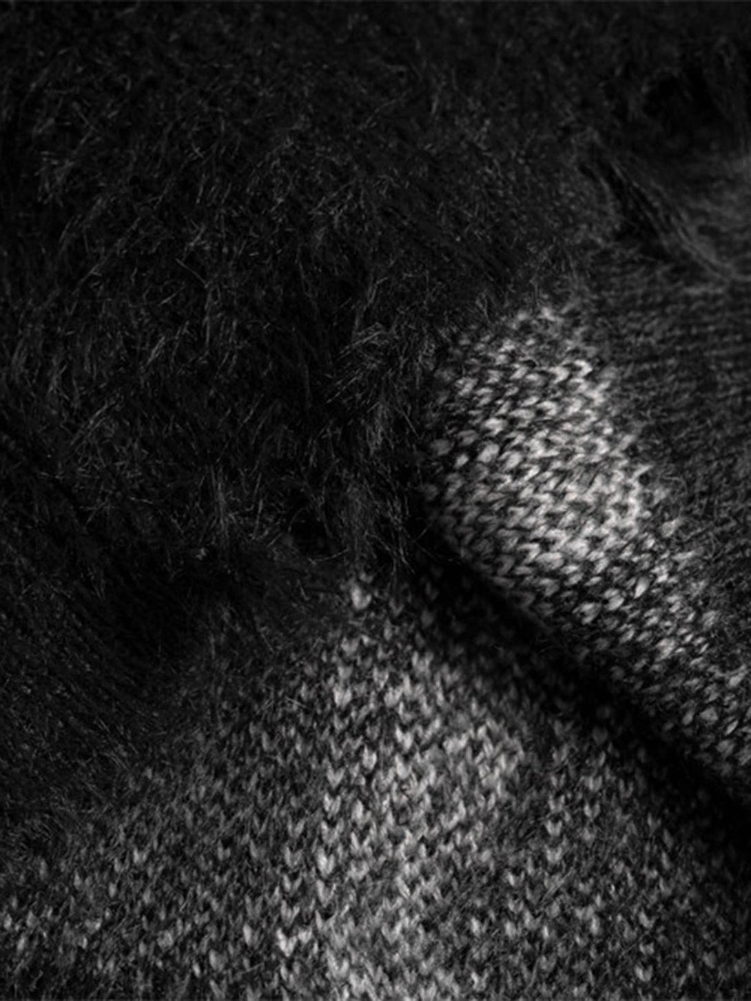 A detailed look at TALISHKO's ripped knit turtleneck sweater, showcasing its intricate texture.