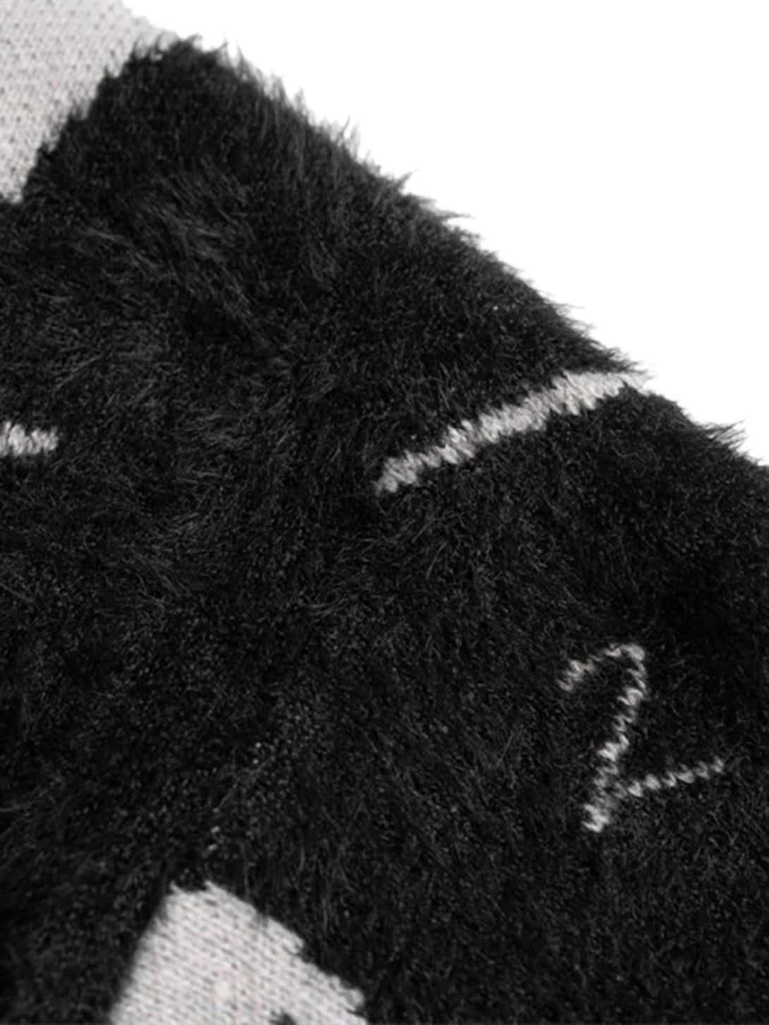 Zoomed-in texture of TALISHKO's ripped knit turtleneck sweater, highlighting its intricate fabric.