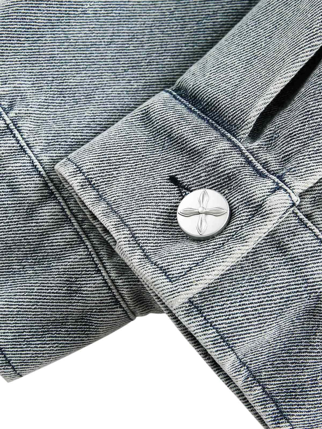 Detailed view of cuff and button on TALISHKO's denim jacket, highlighting texture and stitching.