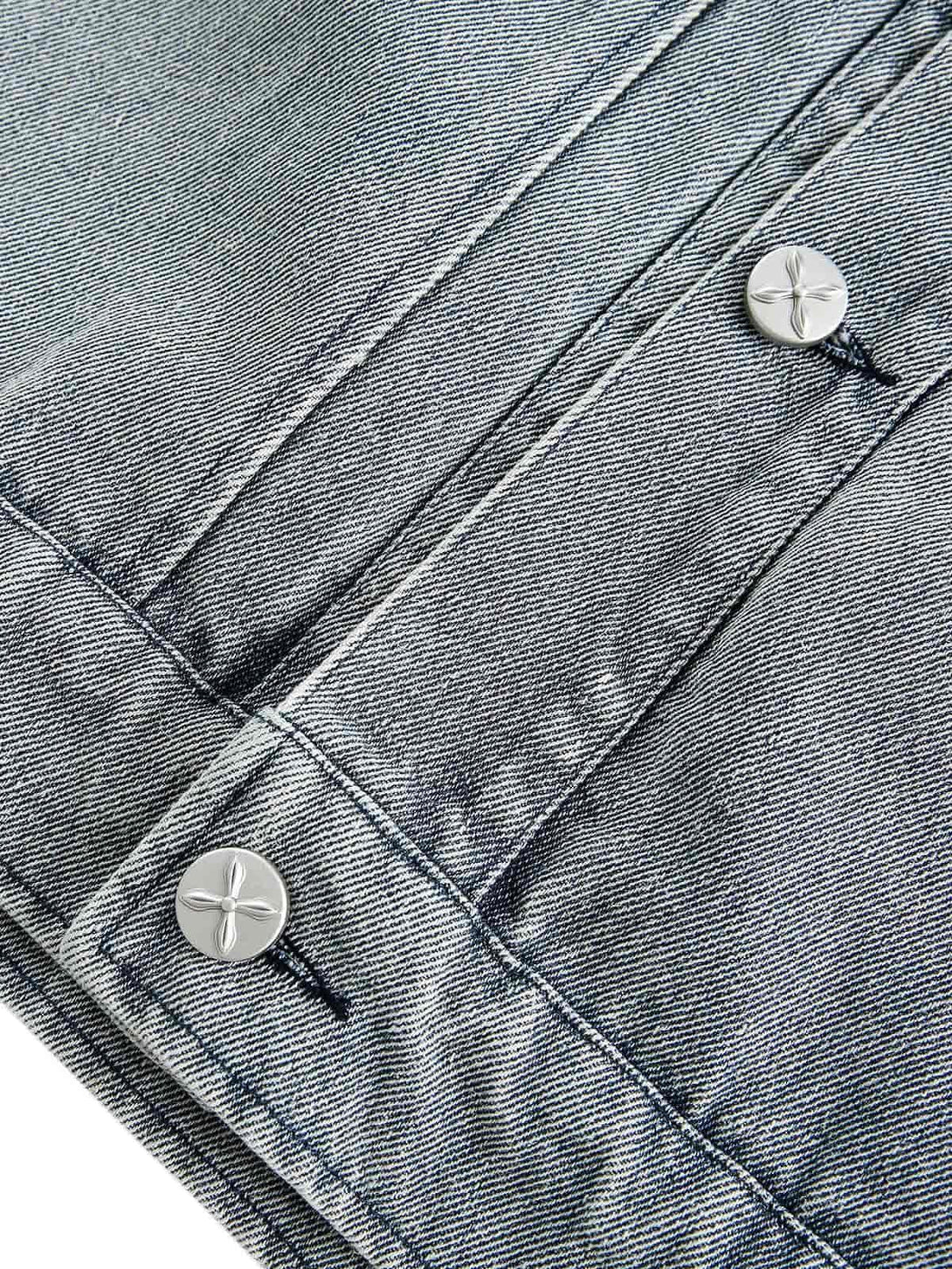 Detailed fabric and stitching on TALISHKO's denim jacket, highlighting button and texture.