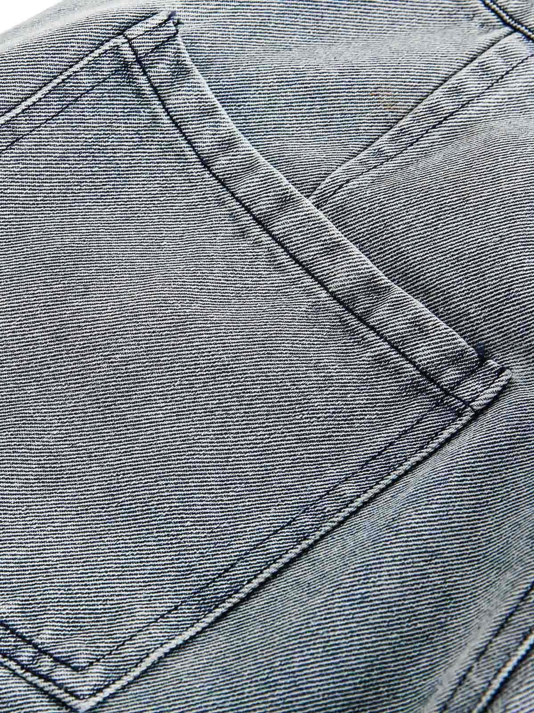 Detailed fabric and stitching on TALISHKO's denim pants, showcasing unique texture and style.