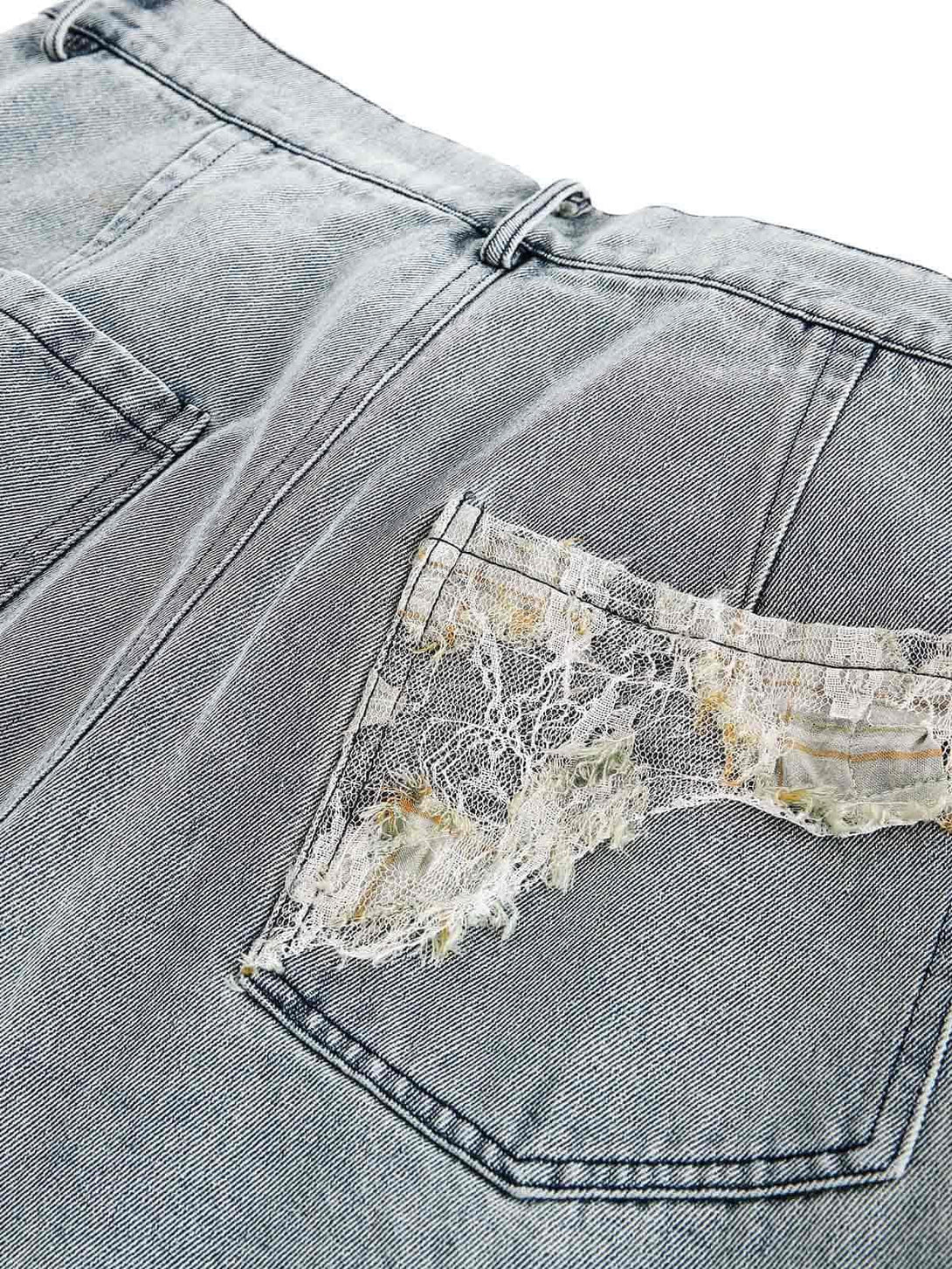 A unique back pocket detail of TALISHKO's denim pants, featuring intricate lace and distressed design.