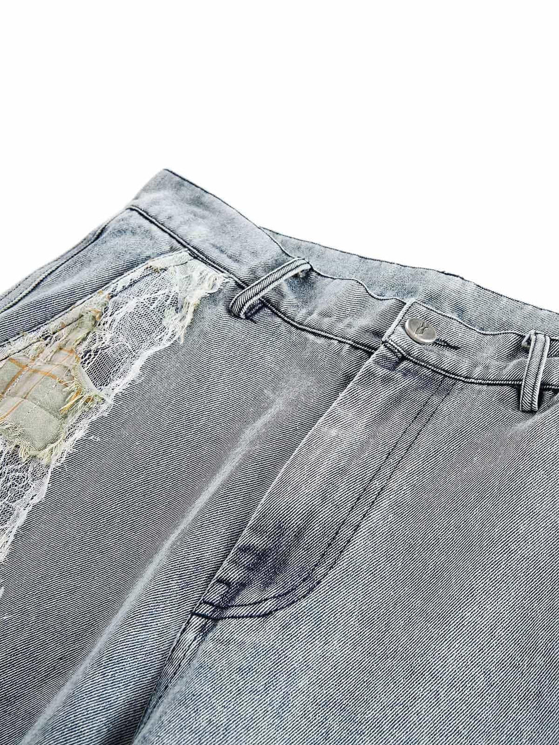 Detailed view of TALISHKO's ripped lace panel denim pants, showcasing unique texture and style.