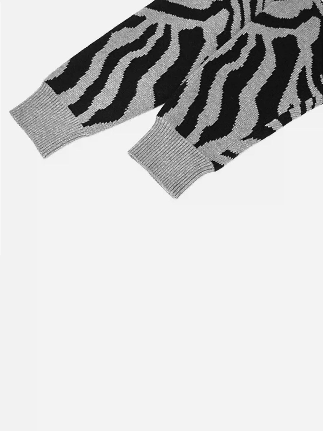 A detailed view of the TALISHKO zebra-pattern sweater cuffs, highlighting intricate design details.