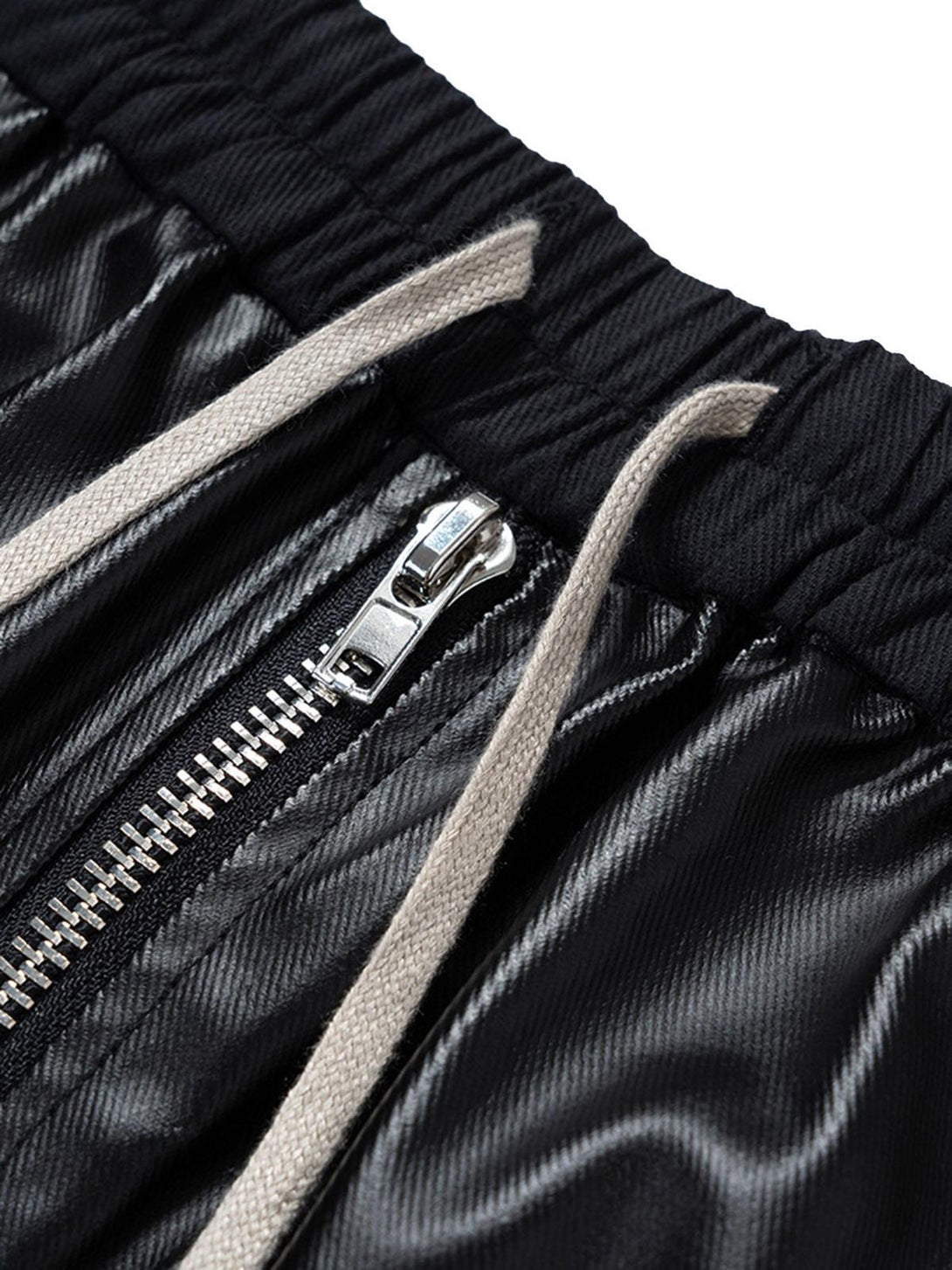 A close-up of TALISHKO overalls highlighting the matte-coated fabric and sleek zipper detail.