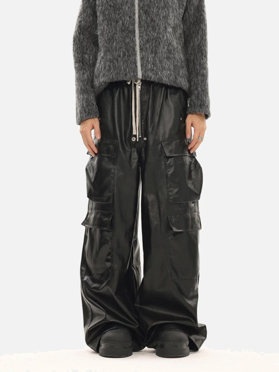 Model in TALISHKO matte coated overalls with multi-pocket design, paired with a textured gray top.