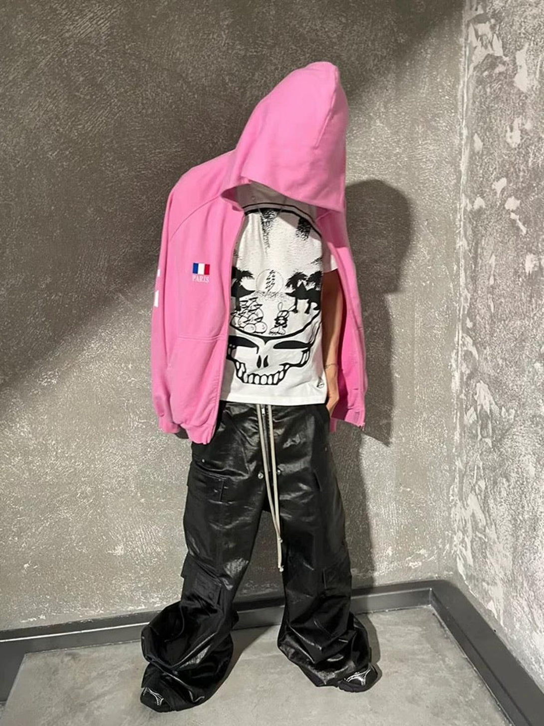 Model in TALISHKO matte overalls with multi-pocket design, styled with a pink hoodie.
