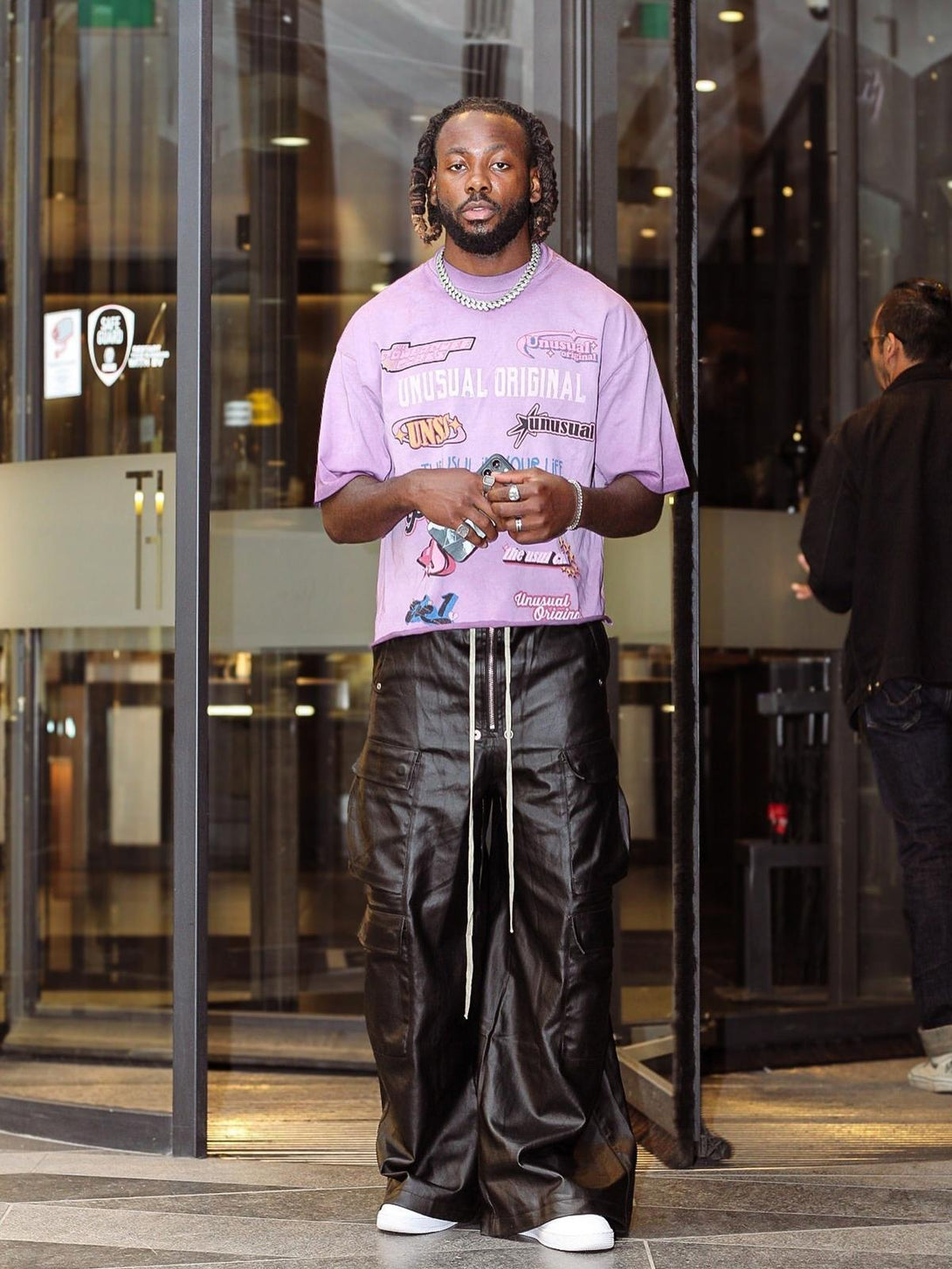 Model wearing TALISHKO matte coated overalls with multi-pocket design, paired with a graphic tee.