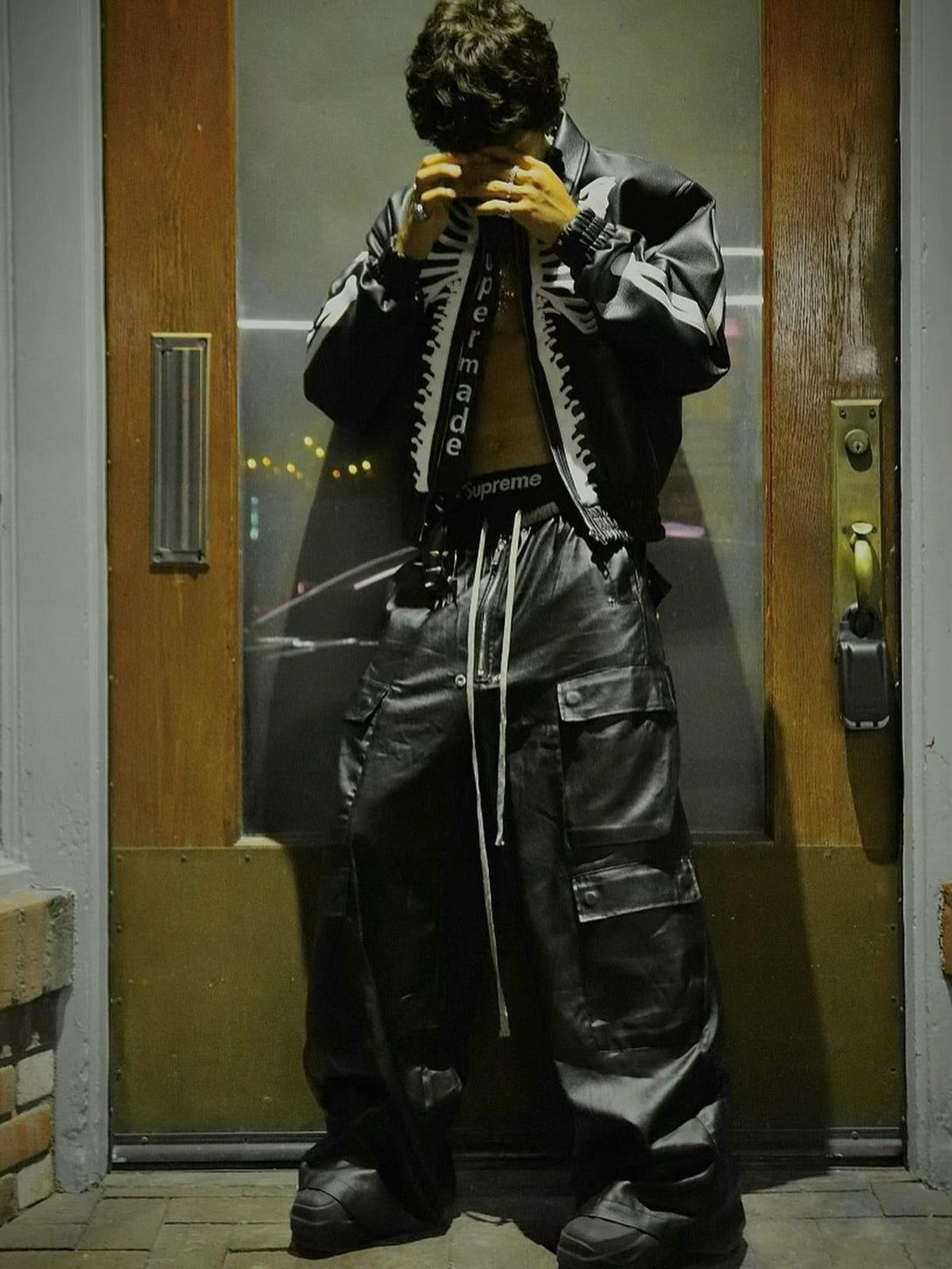 Model in TALISHKO matte overalls, multi-pocket design, paired with a black jacket.