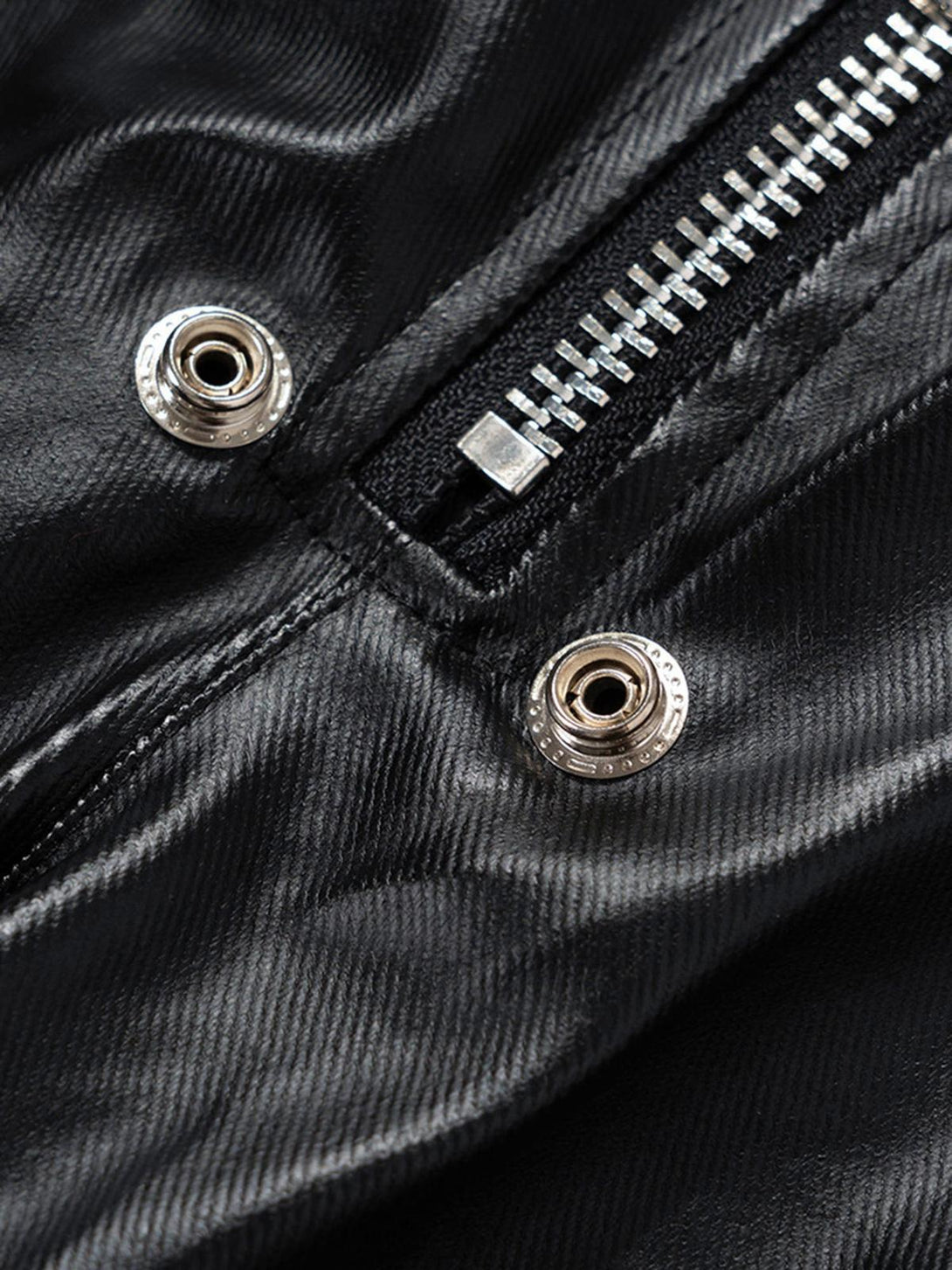 A close-up of TALISHKO overalls showcasing the matte-coated fabric and metallic zipper detail.