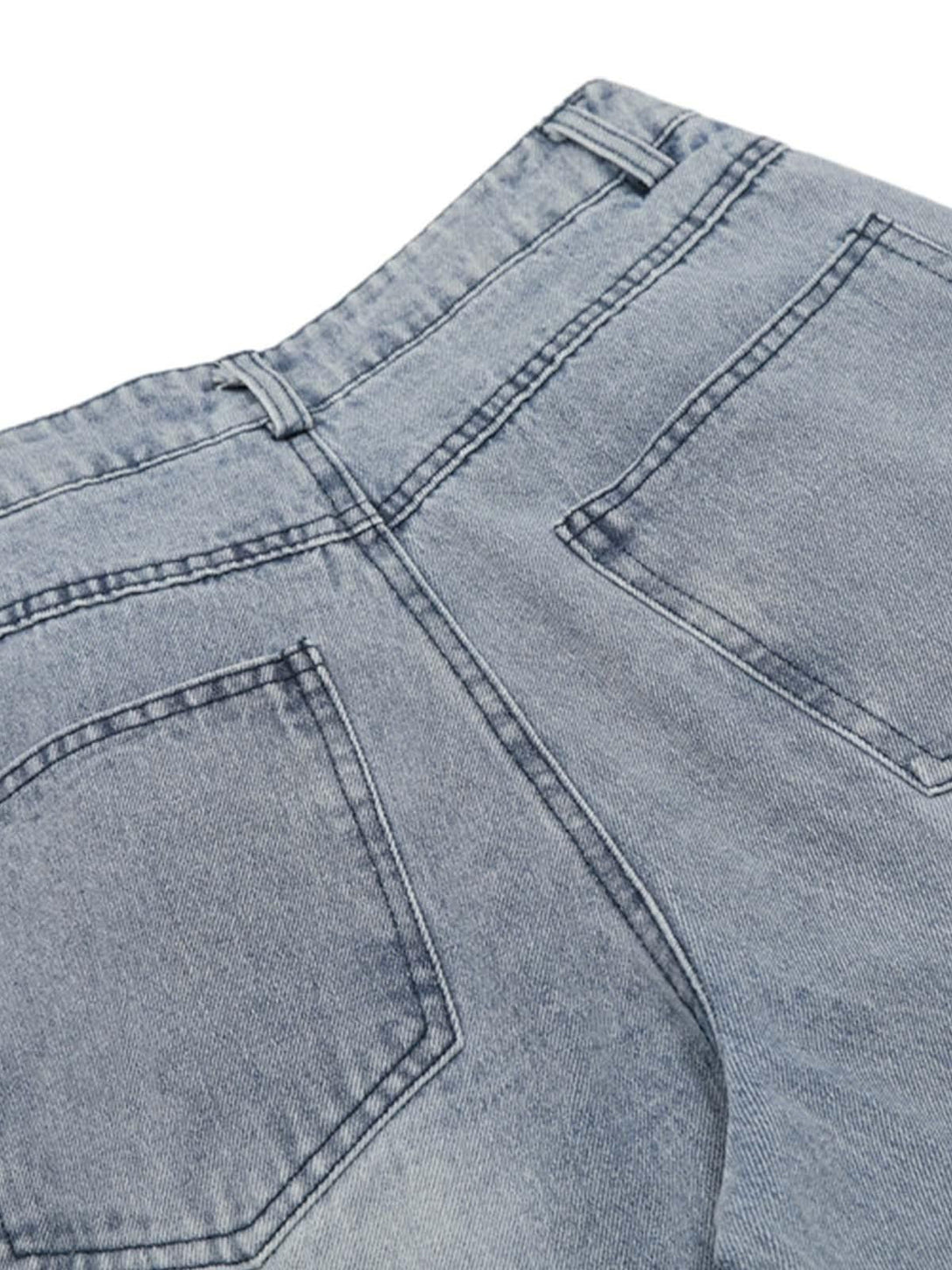 Back pocket detail of TALISHKO pleated baggy jeans showcasing stitching and light wash.