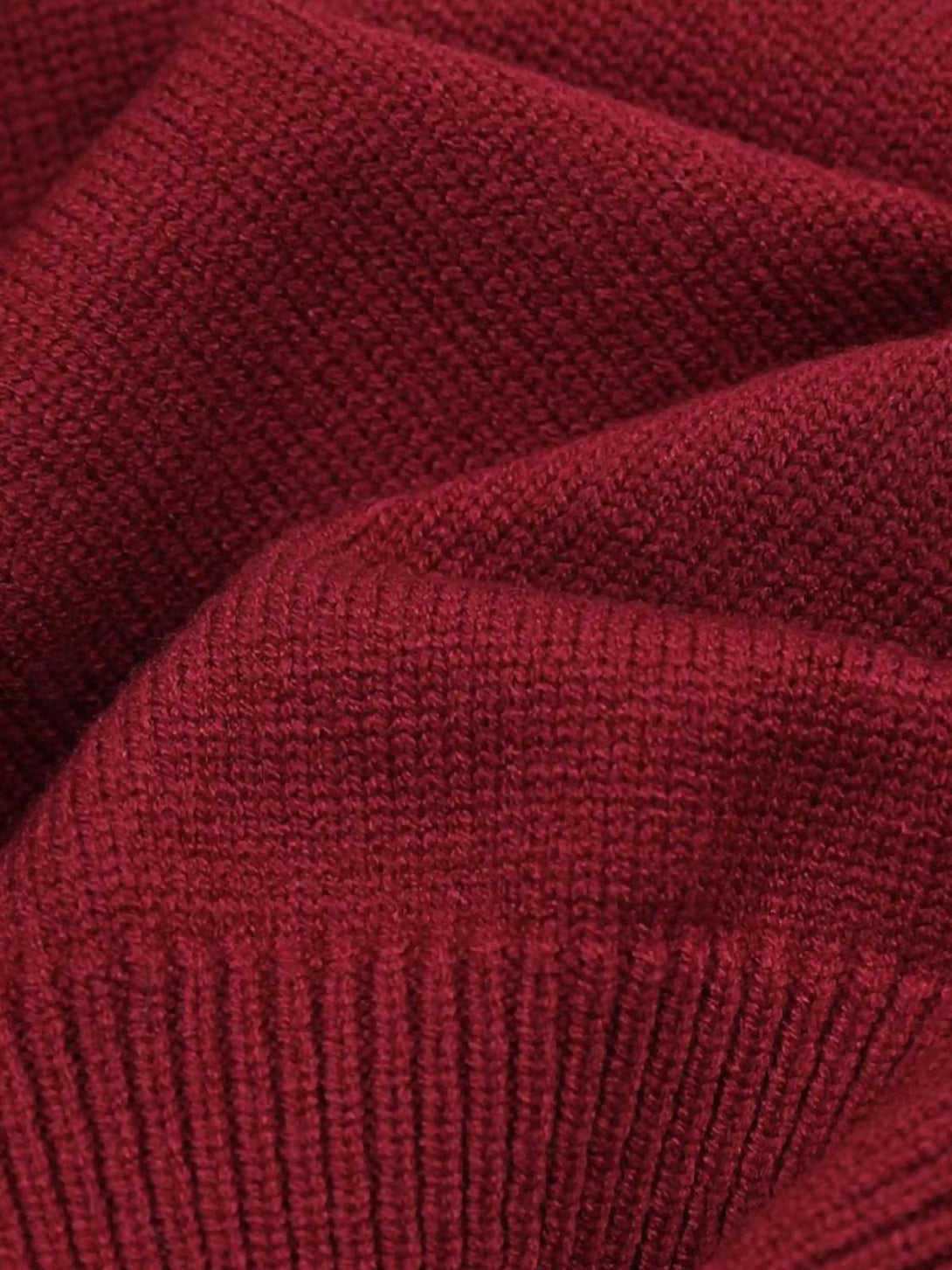 A close-up of TALISHKO's red sweater, showcasing the cozy knit texture and intricate detail.