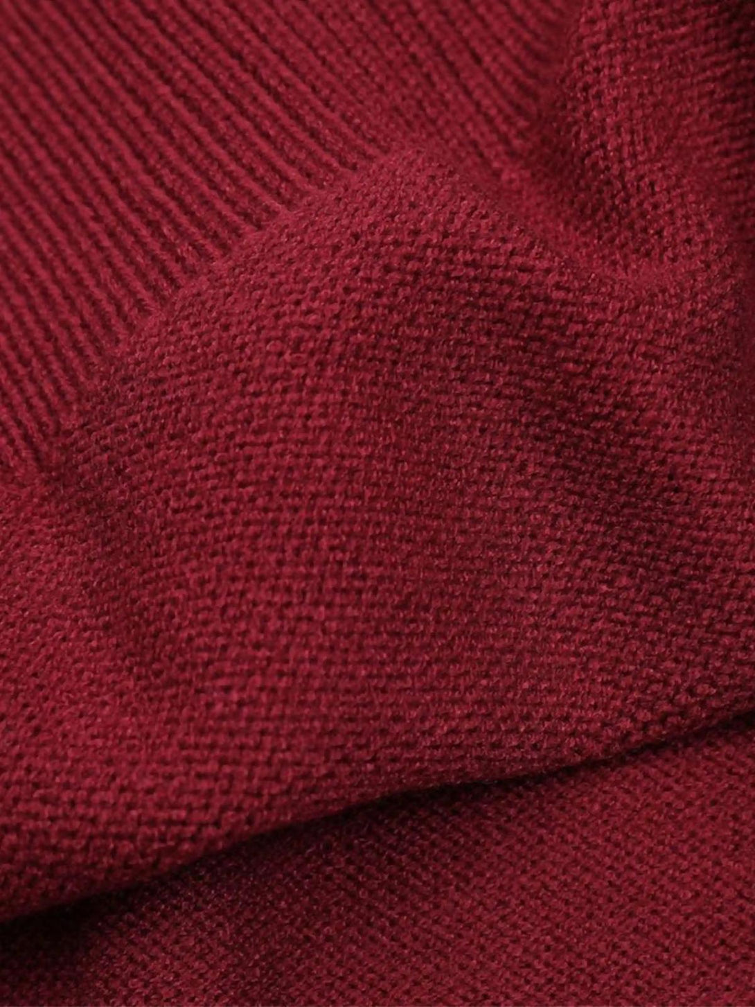 Focusing on the rich texture of TALISHKO's red sweater, highlighting its soft knit fabric.
