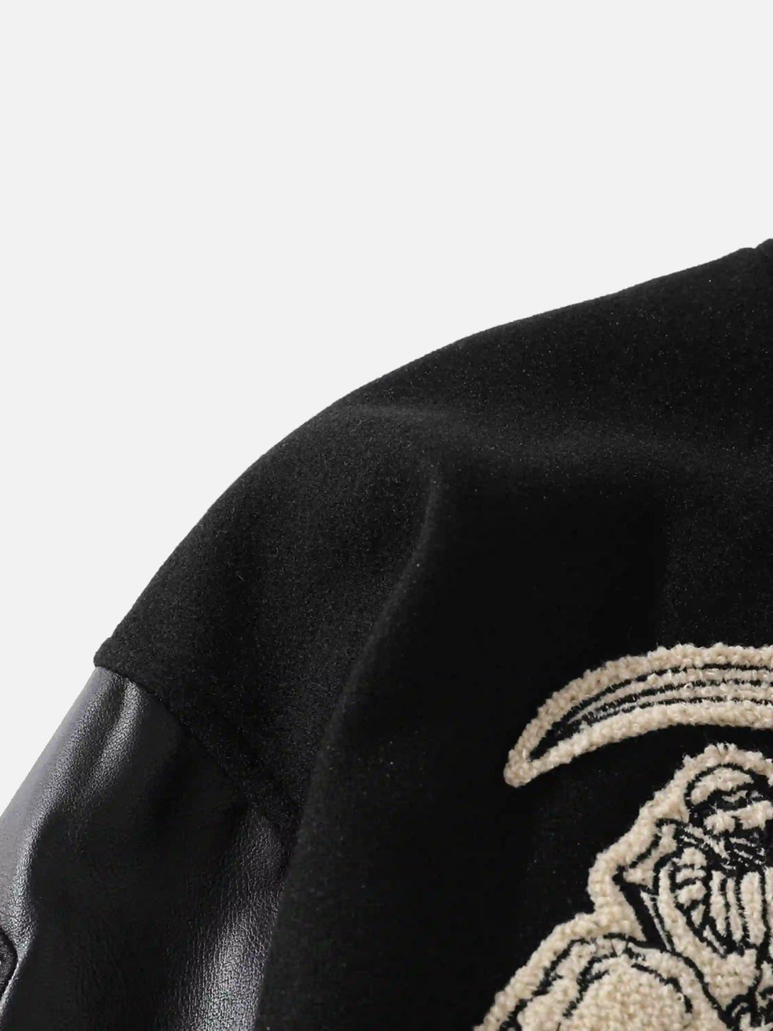 Intricate look at TALISHKO jacket's skull embroidery and PU sleeve detail.