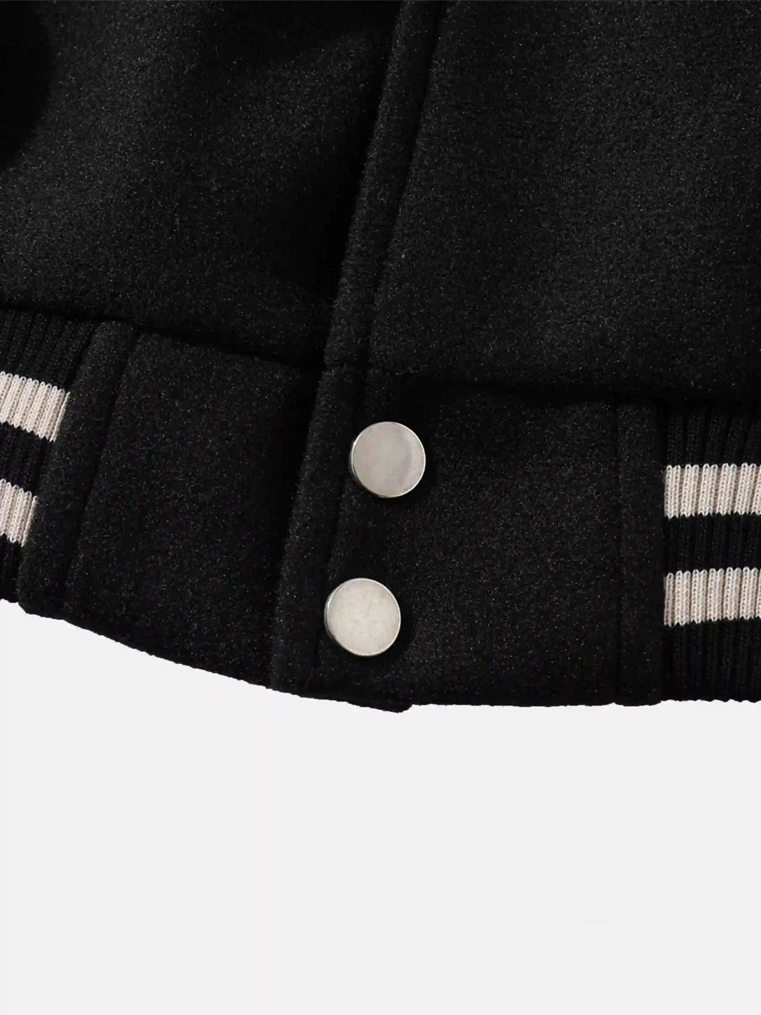 Close-up of TALISHKO jacket's hem with striped ribbing and button detail, highlighting craftsmanship.
