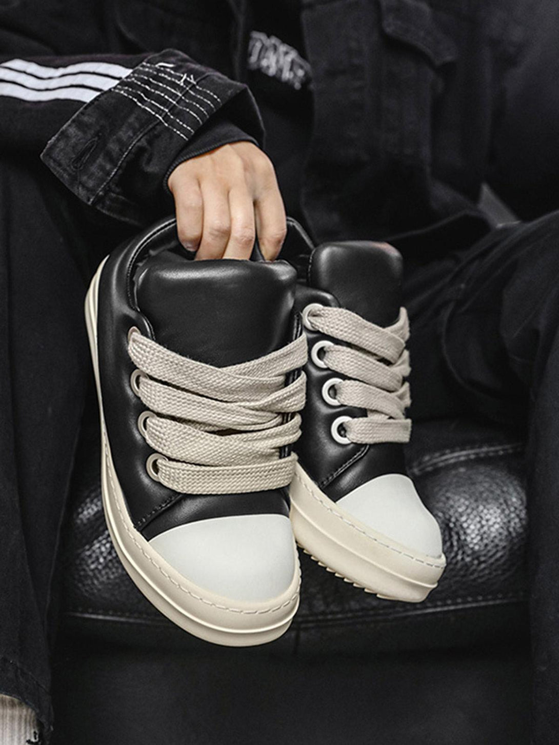 TALISHKO slip-on sneakers with black leather and wide cream laces, showcasing urban style.