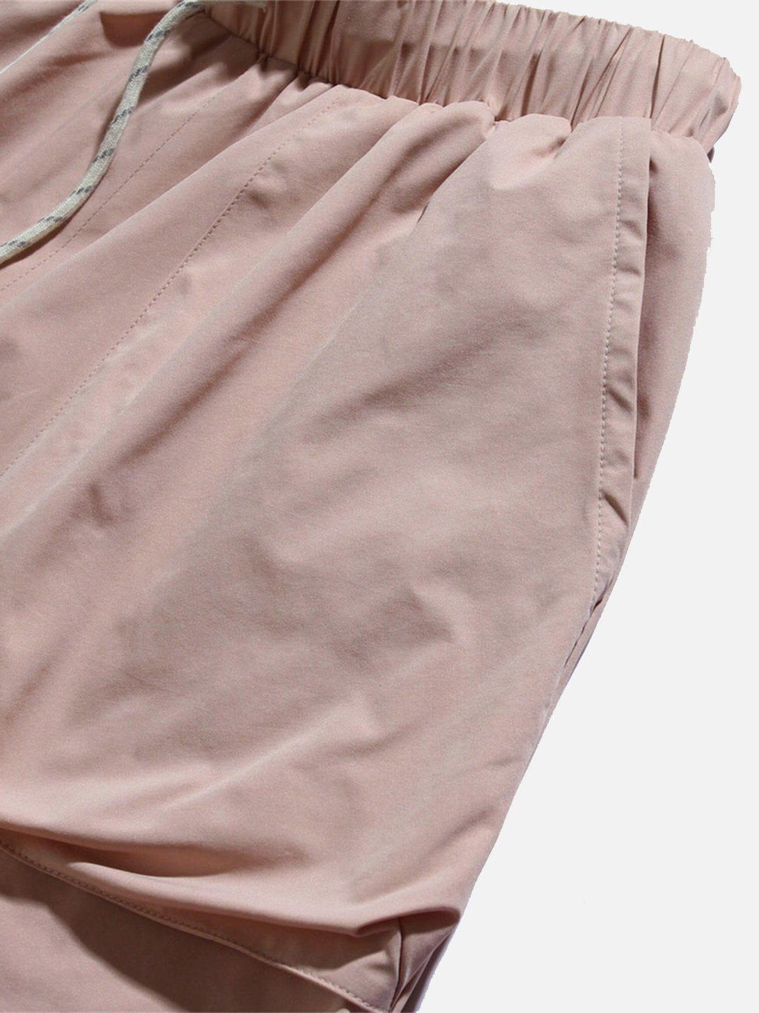 Focusing on the pink fabric and drawstring design of TALISHKO shorts, highlighting pocket detail.