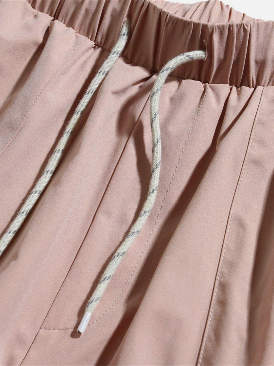 Detailed view of TALISHKO pink drawstring shorts with large pockets, perfect for casual wear.