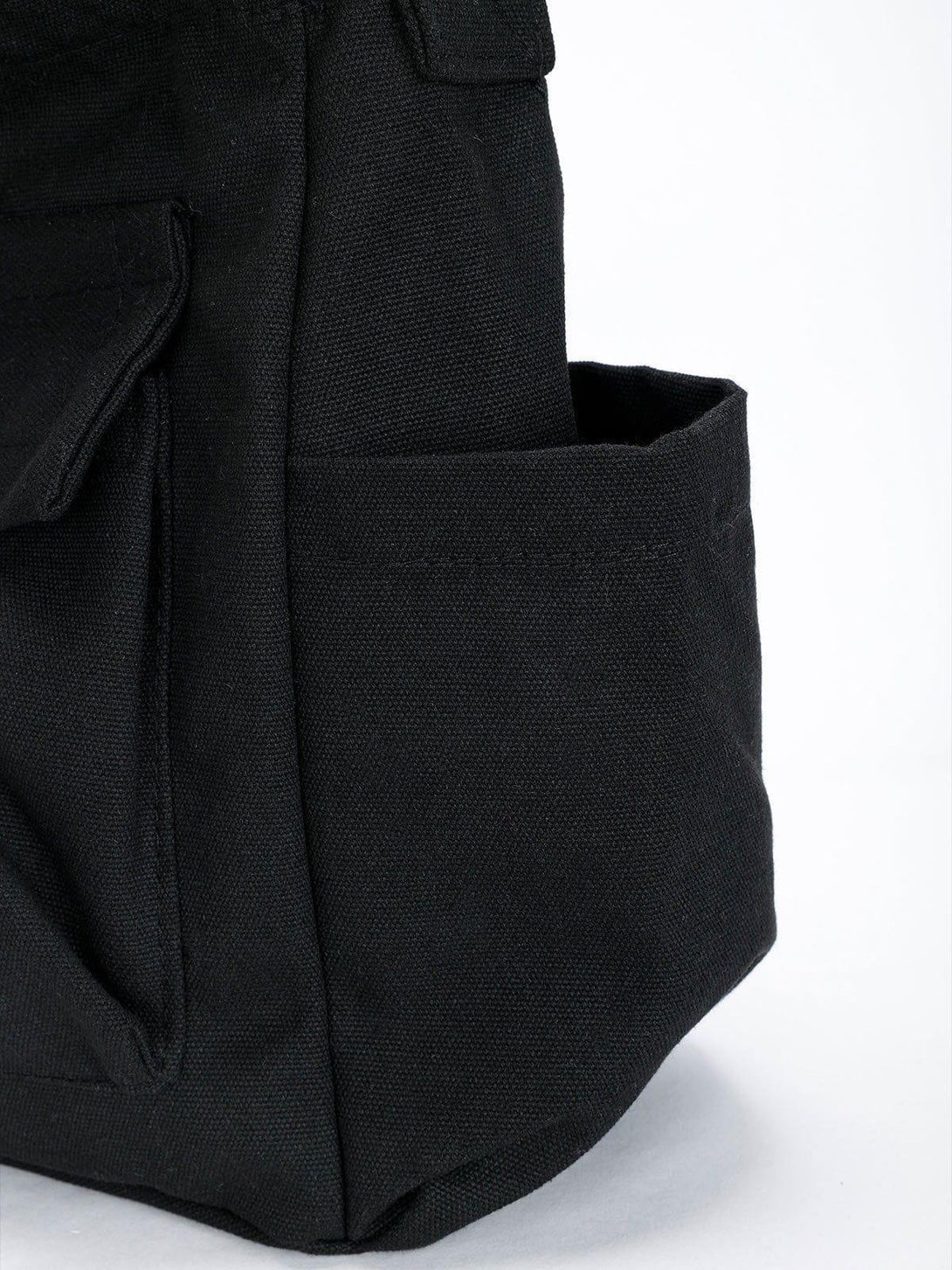 A detailed view of TALISHKO's black shoulder bag, highlighting its spacious pocket design.