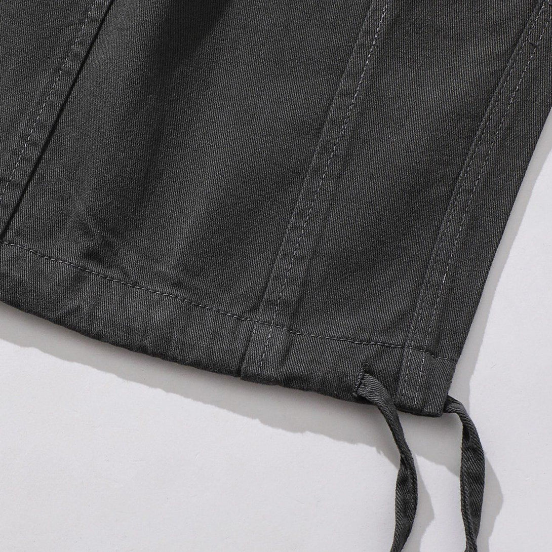 Detailed fabric and stitching of dark pants by TALISHKO, featuring drawstring cuffs.