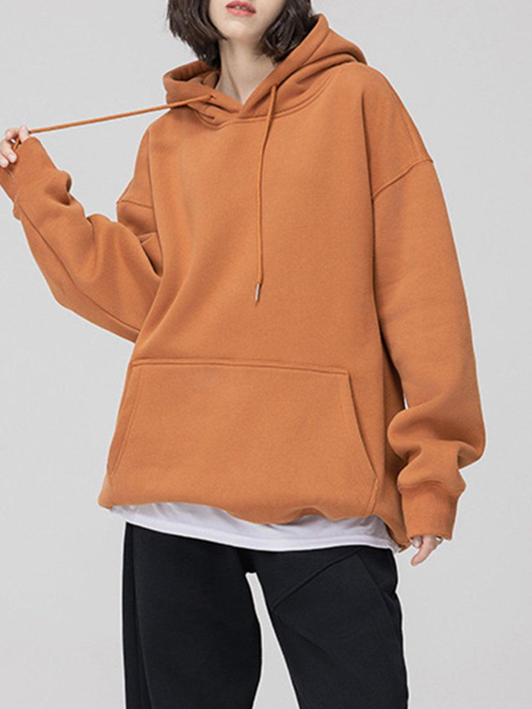 Model wearing a brown drawstring hoodie by TALISHKO, featuring a relaxed and cozy fit.
