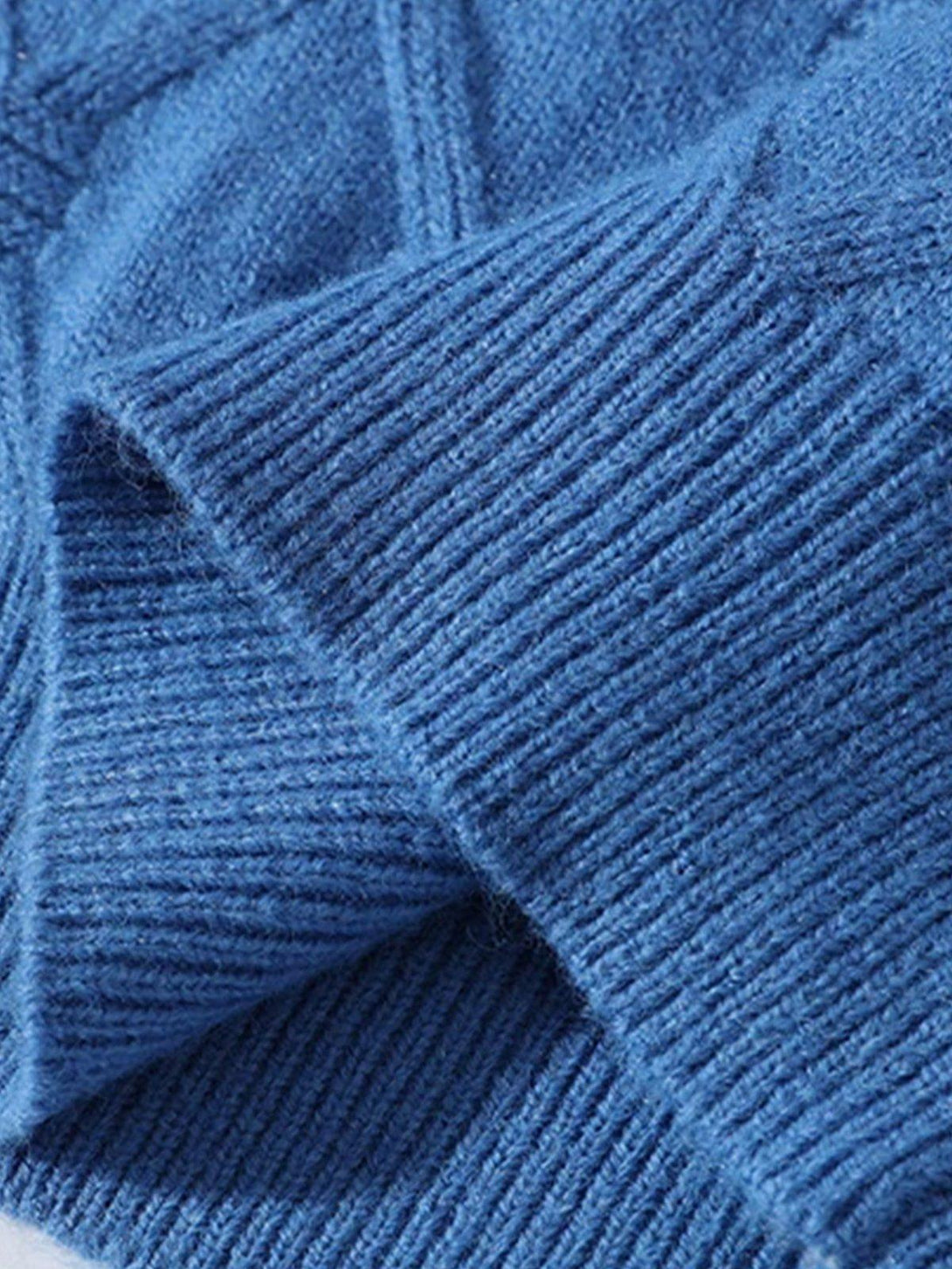 Zoomed-in texture of TALISHKO's blue knit sweater, highlighting its ribbed and cozy fabric.